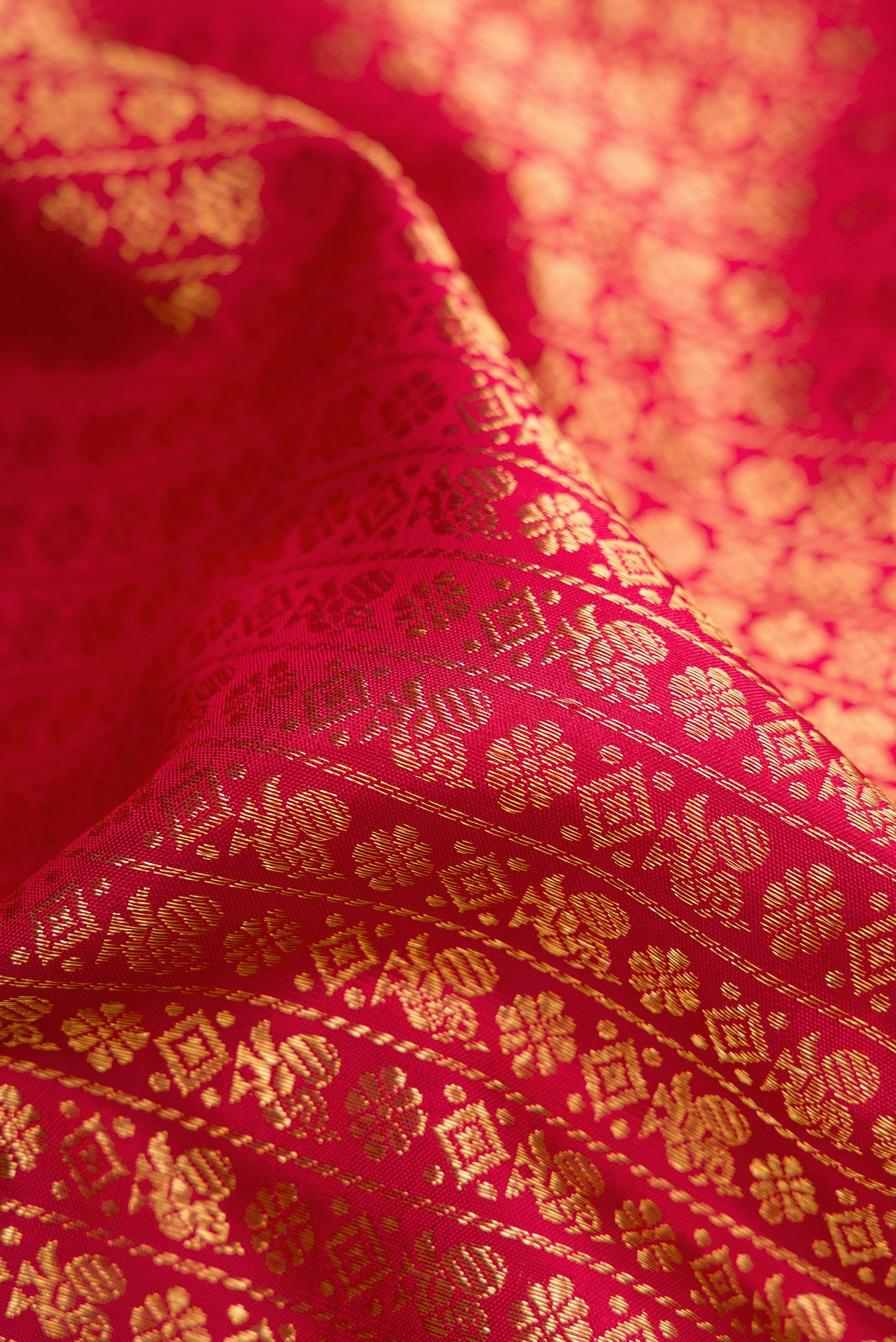 Close up of Maroon Dual Tone Kanchipuram Silk Saree with Zari Brocade on the body and Zari Border.  displaying folds