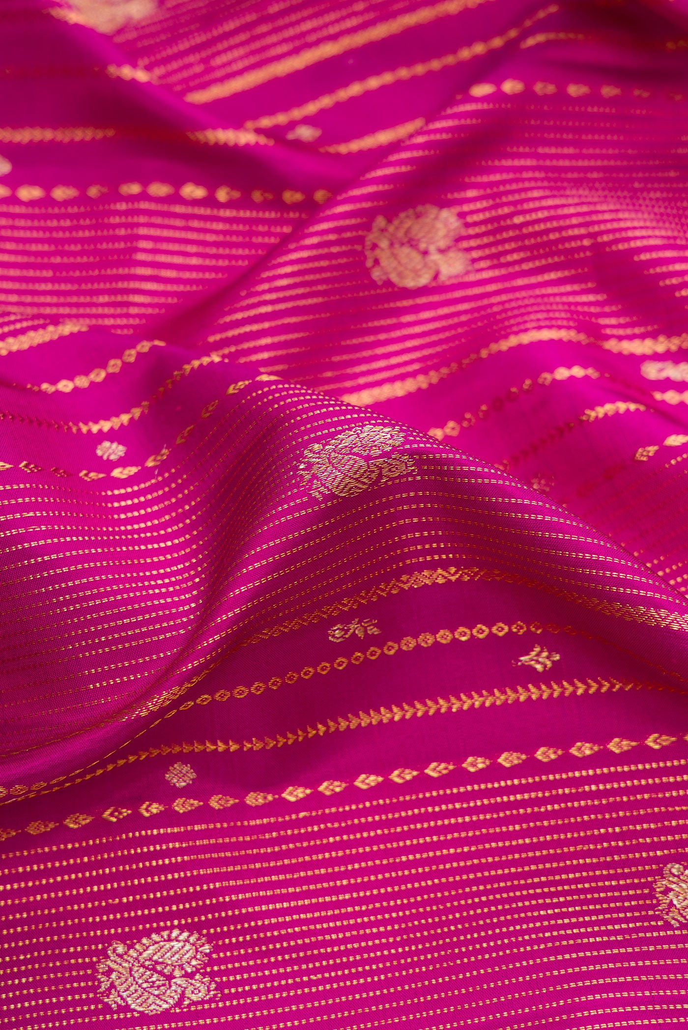 Close up of Magenta Dual Tone Kanchipuram Silk Saree with Zari Brocade on the body and Zari Border.  displaying folds
