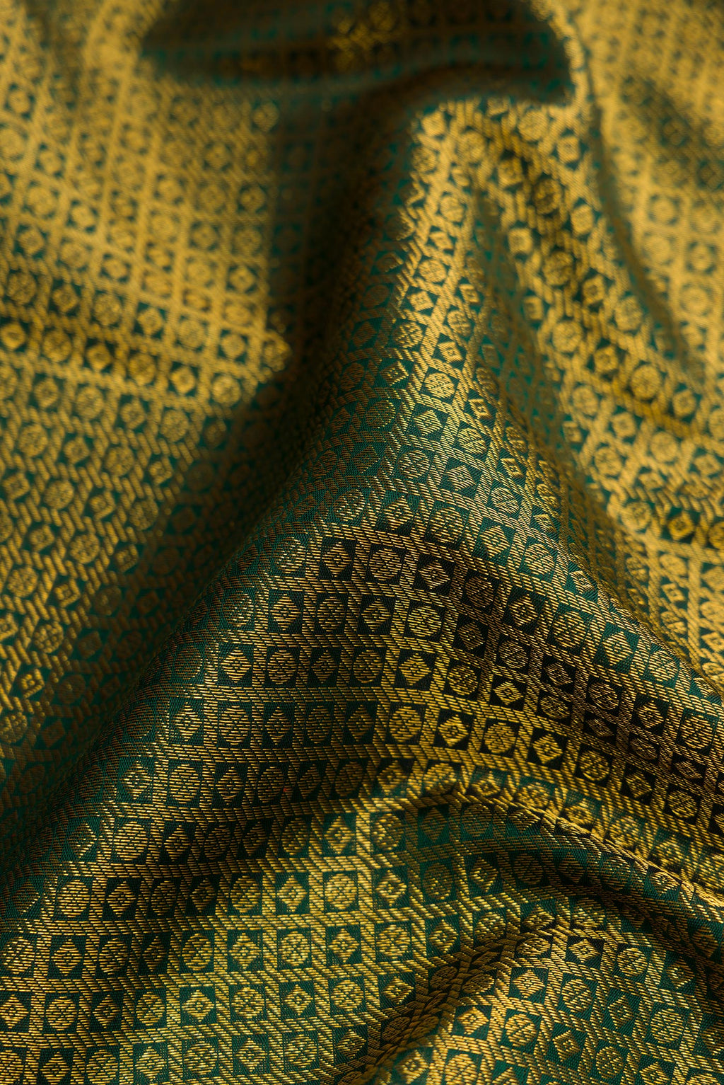 Close up of Green Dual Tone Kanchipuram Silk Saree with Zari Brocade on the body and Zari Border.  displaying folds