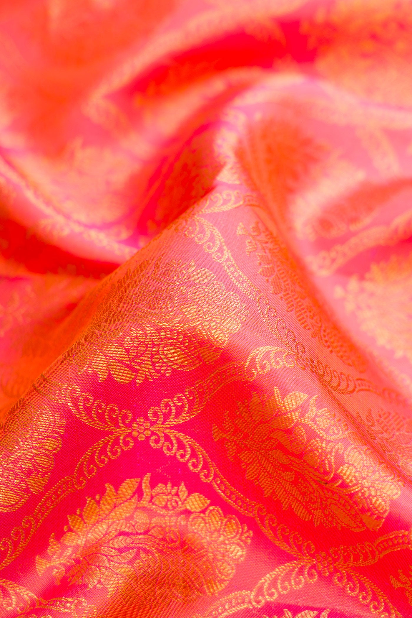 Close up of Peach Dual Tone Kanchipuram Silk Saree with Zari Brocade on the body and Zari Border.  displaying folds