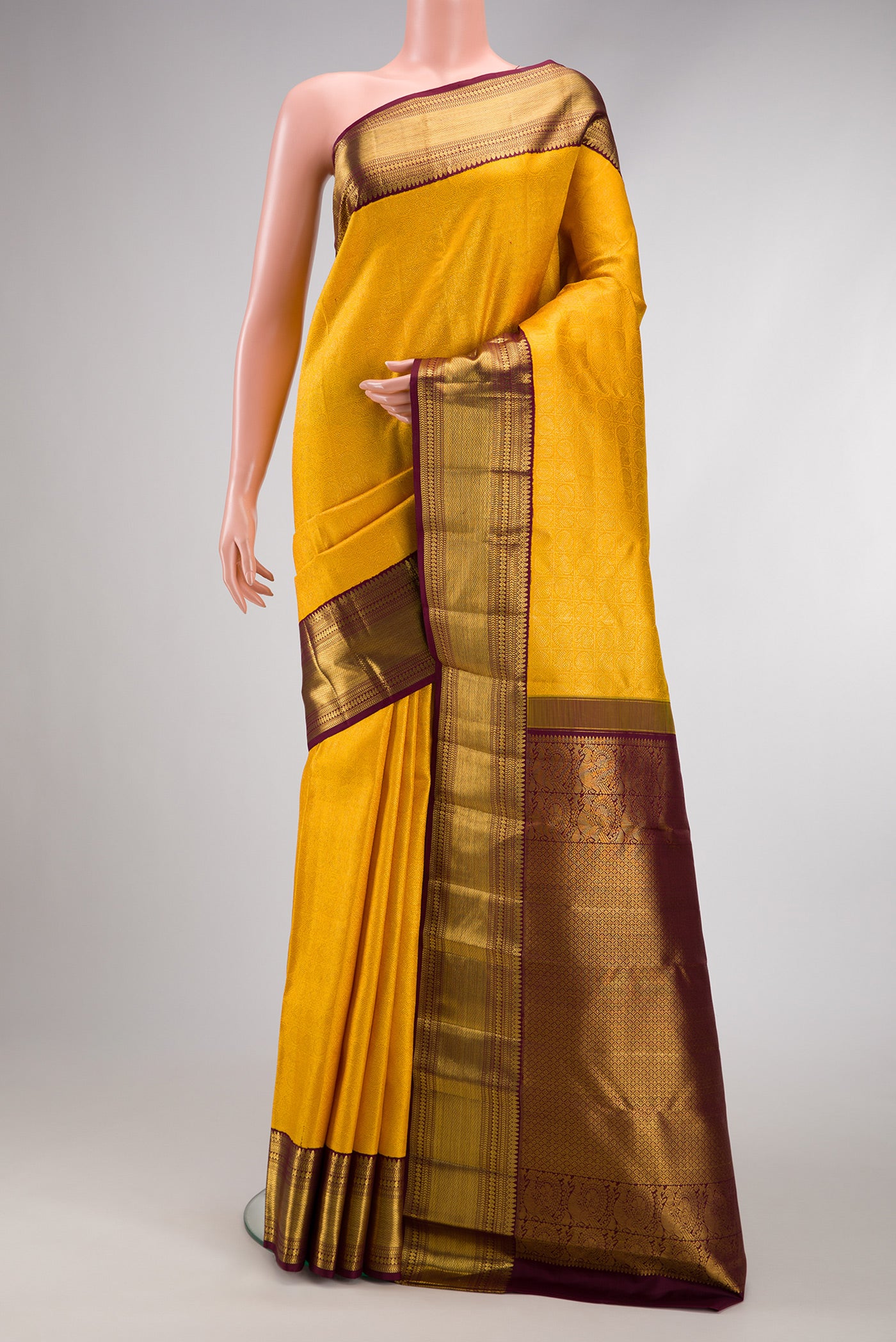 Yellow Dual Tone Kanchipuram Silk Saree with Zari Brocade on the body and Zari Border.  displayed on a mannequin