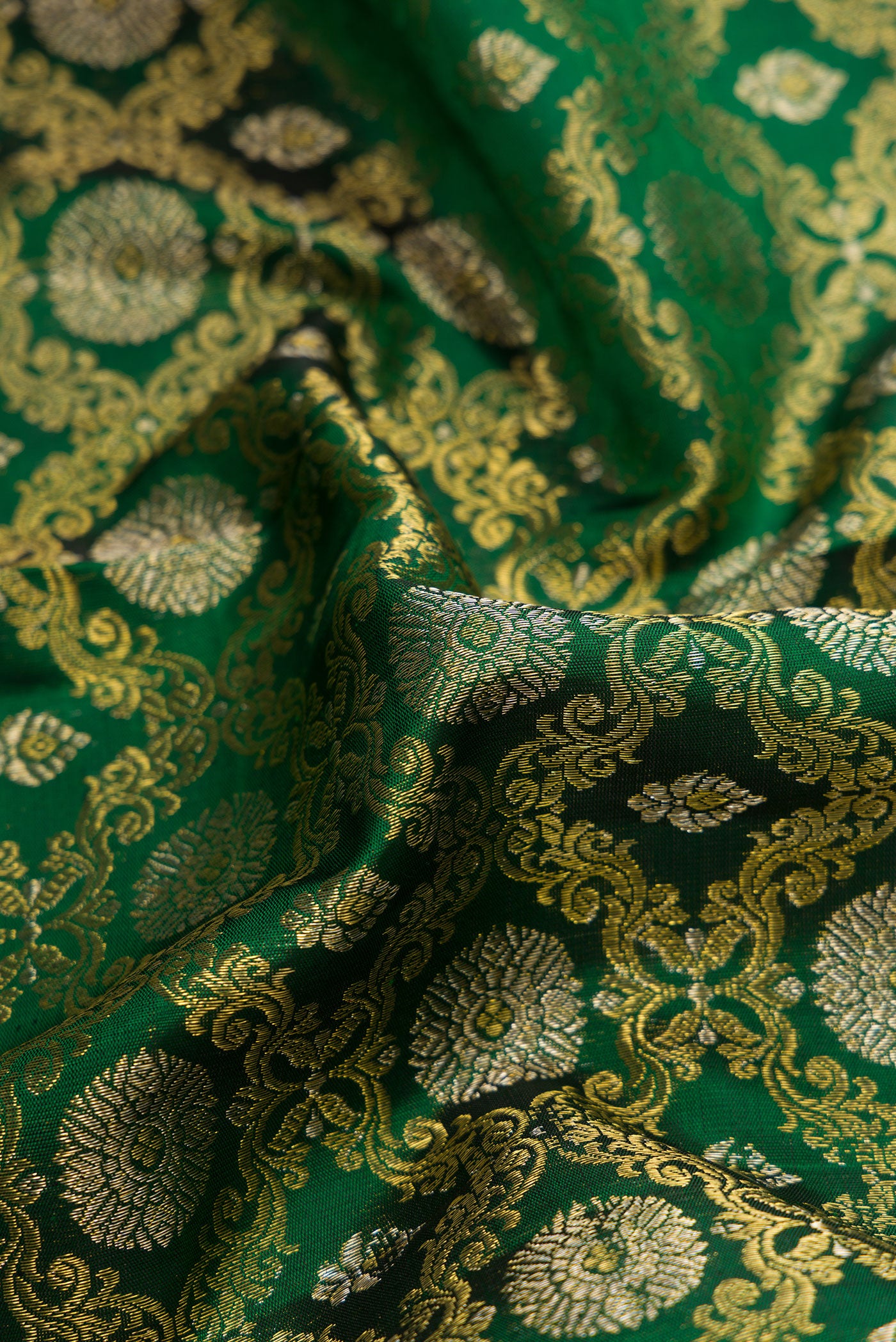 Close up of Green Dual Tone Kanchipuram Silk Saree with Zari Brocade on the body and Zari Border.  displaying folds