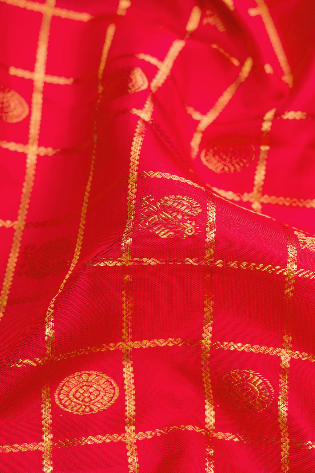 Close up of Red Dual Tone Kanchipuram Silk Saree with Checked design on the body and Zari Border.  displaying folds