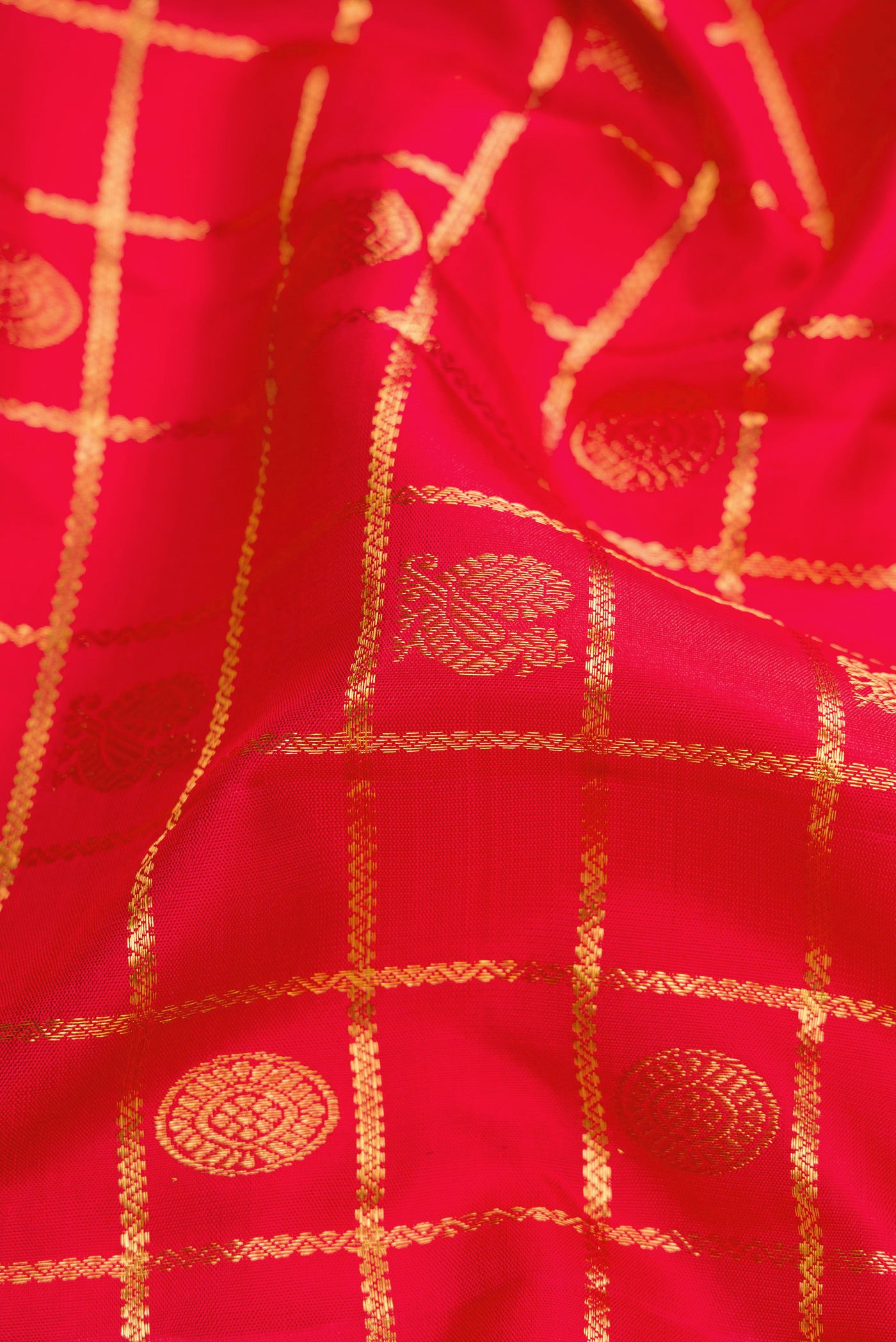 Close up of Red Dual Tone Kanchipuram Silk Saree with Checked design on the body and Zari Border.  displaying folds