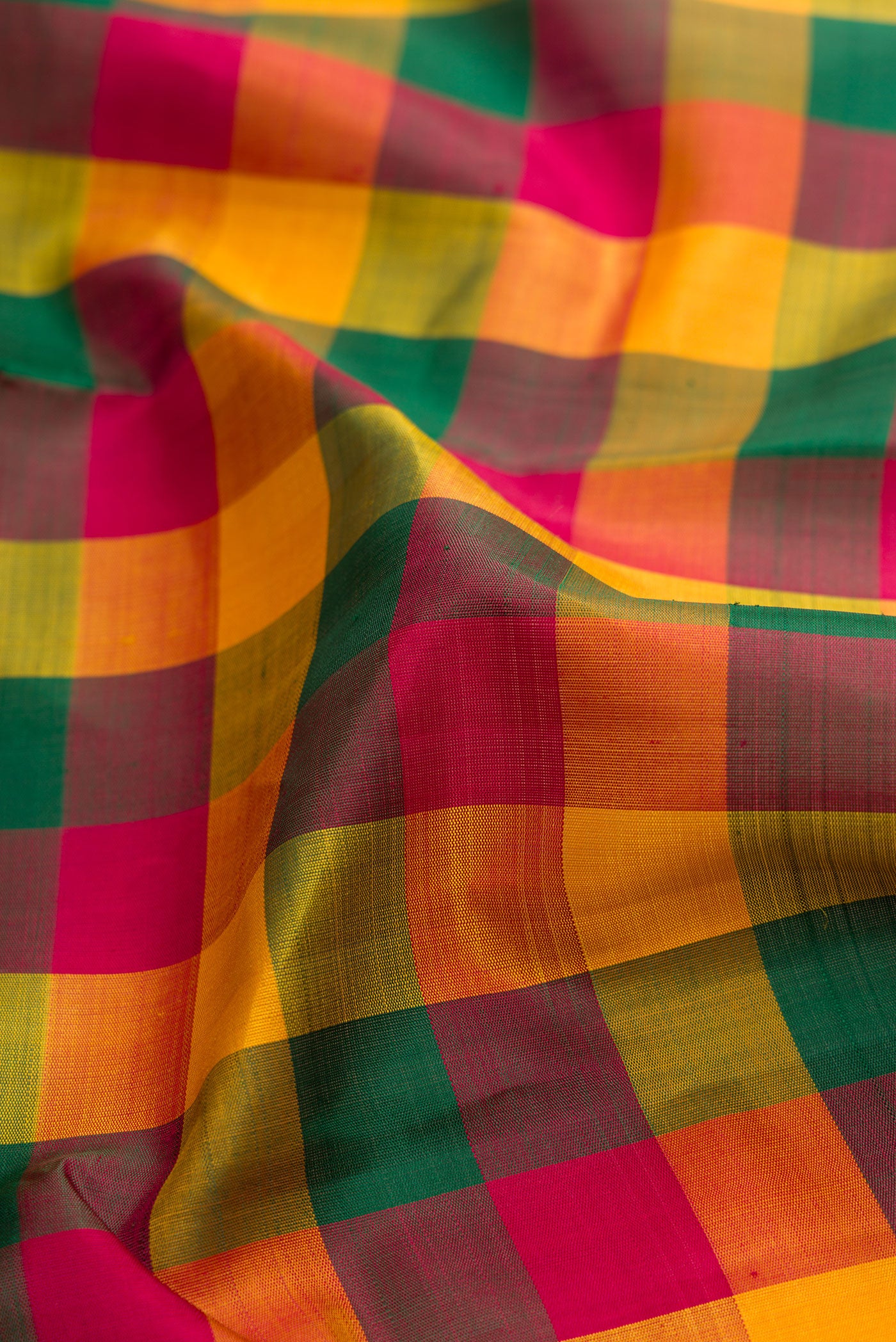 Close up of Pure Silk Pure Zari Green, Yelloe and Maroon Color Kanjivaram Saree with Checked design on the body and Zari Border.  displaying folds