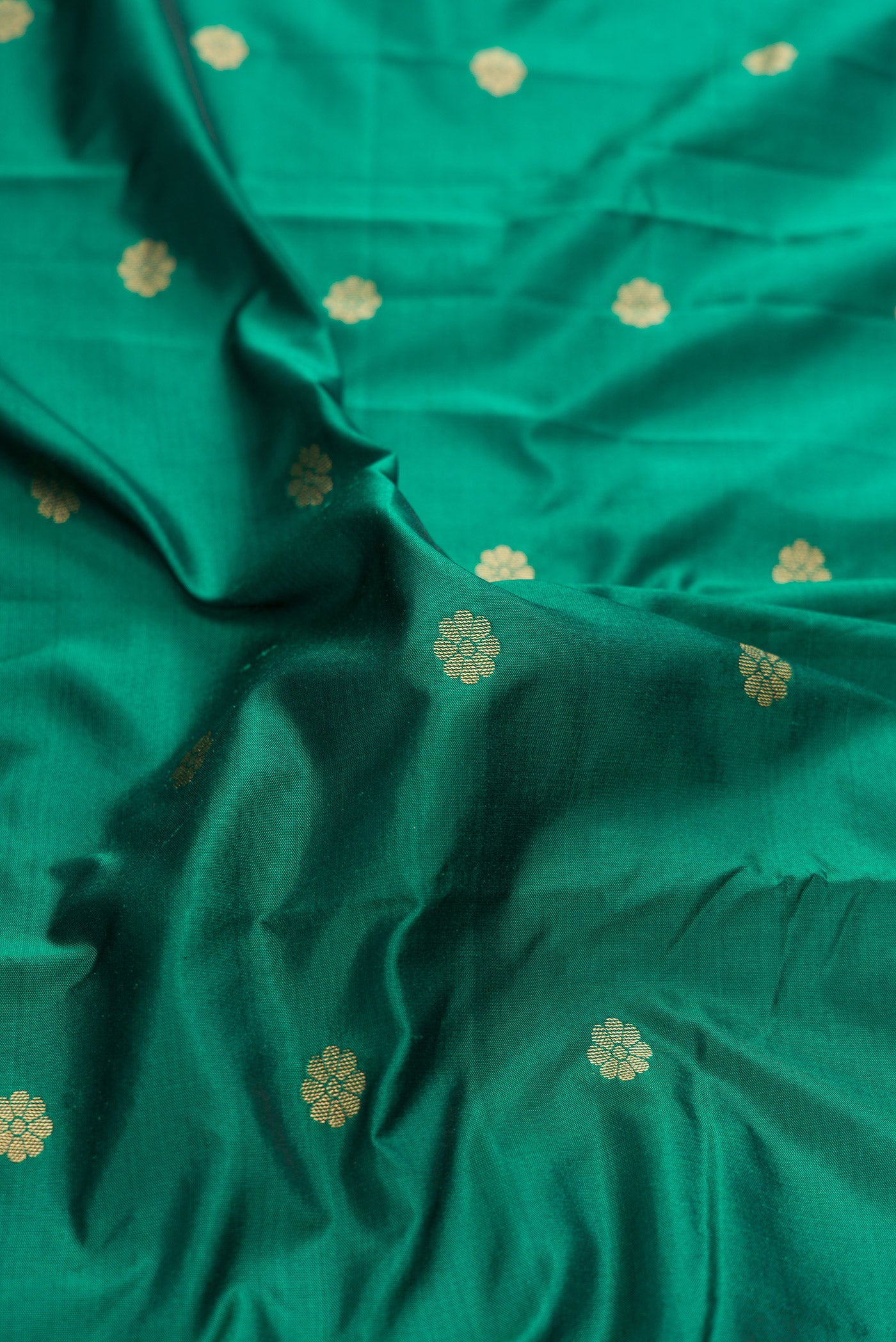 Close up of Green Dual Tone Blended Paithani Silk Saree with Zari Butta on the body and Zari Border.  displaying folds