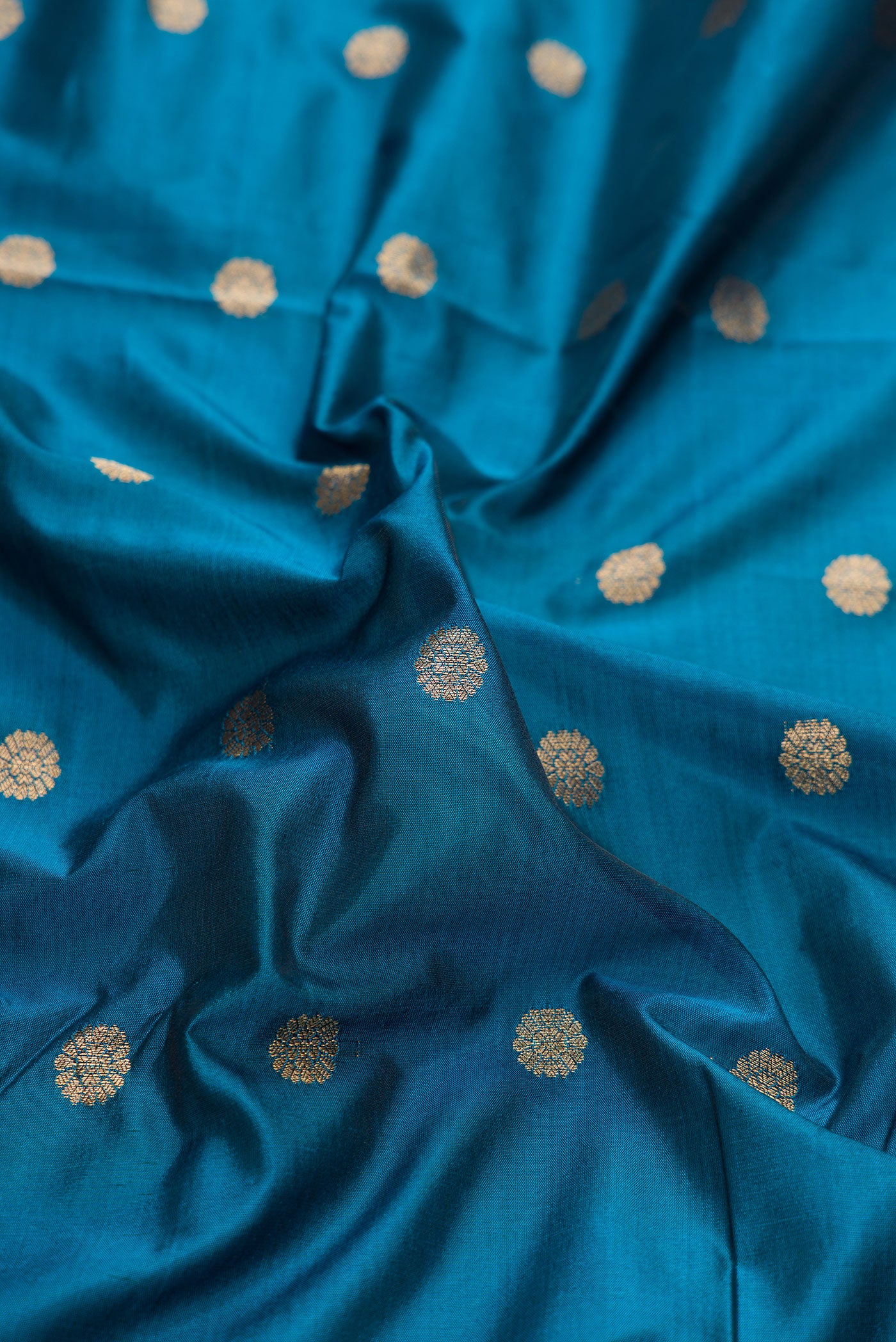 Close up of Peacock Blue Dual Tone Blended Paithani Silk Saree with Zari Butta on the body and Zari Border.  displaying folds
