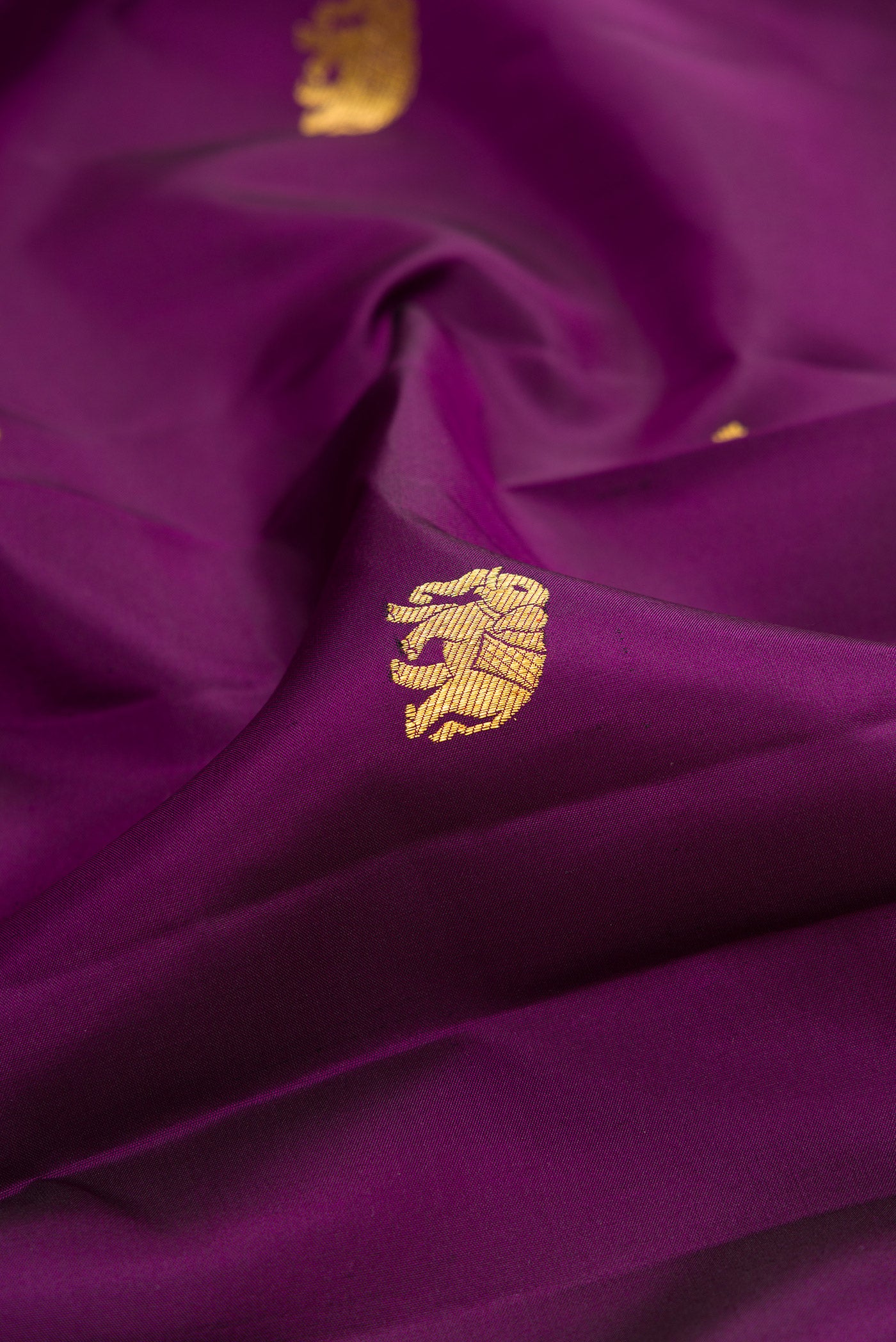 Close up of Purple Kanchipuram Silk Saree with Zari Butta on the body and Zari Border.  displaying folds