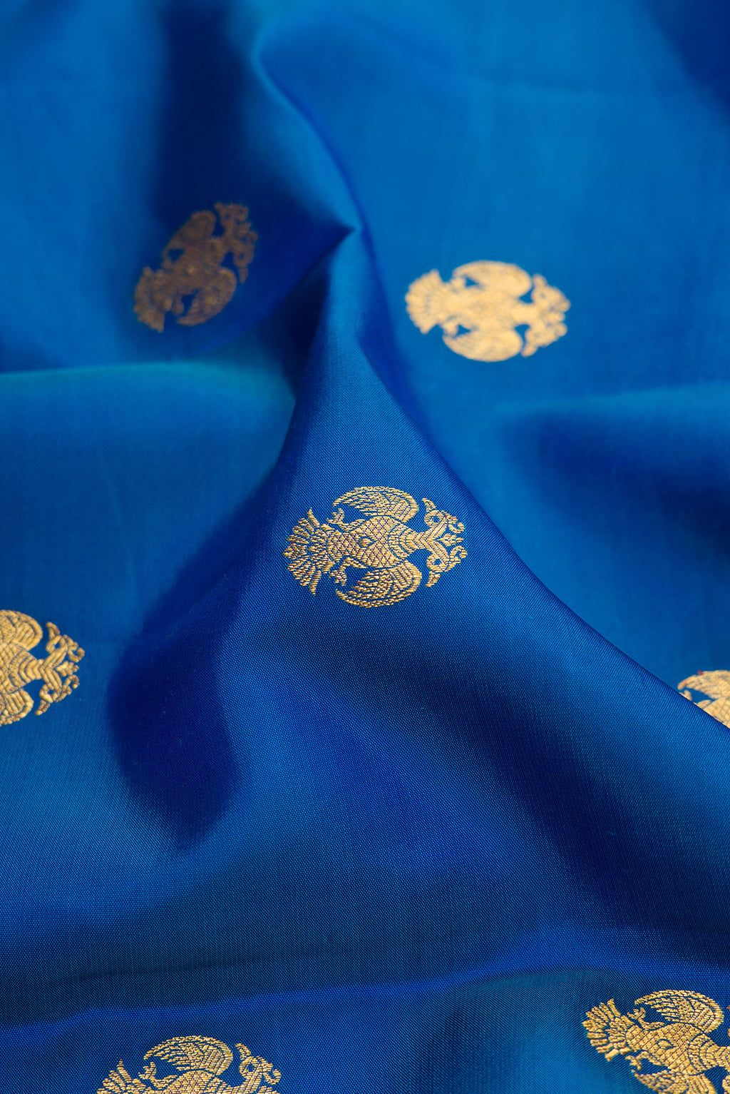 Close up of Peacock Blue Kanchipuram Silk Saree with Zari Butta on the body and Zari Border.  displaying folds