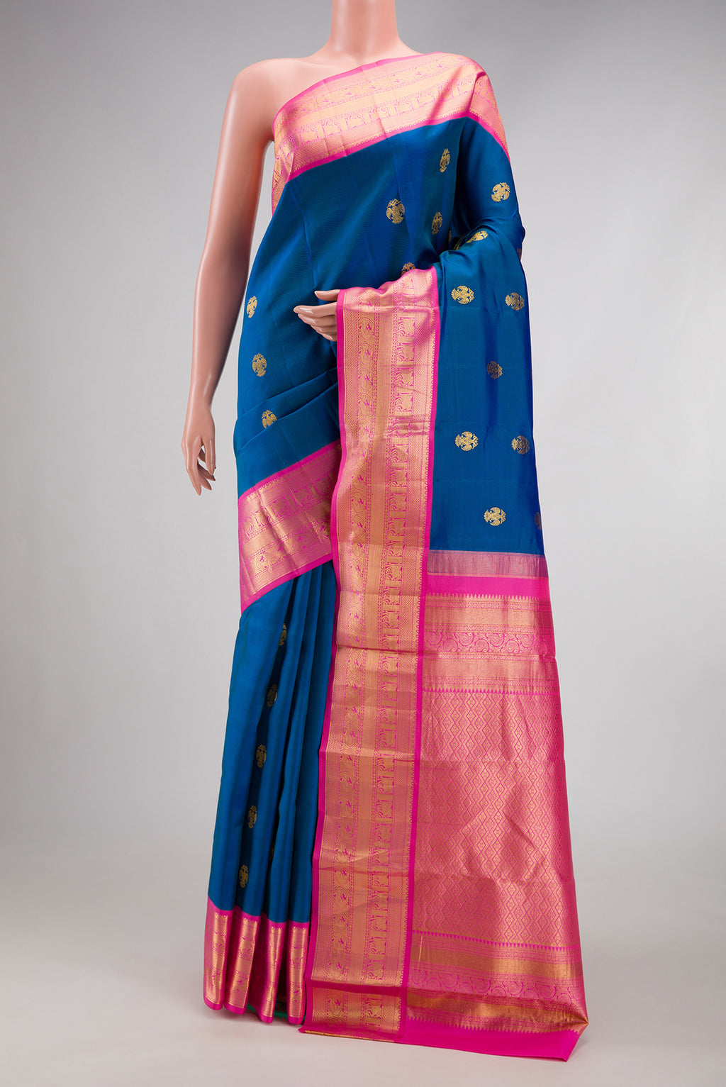 Peacock Blue Kanchipuram Silk Saree with Zari Butta on the body and Zari Border.  displayed on a mannequin