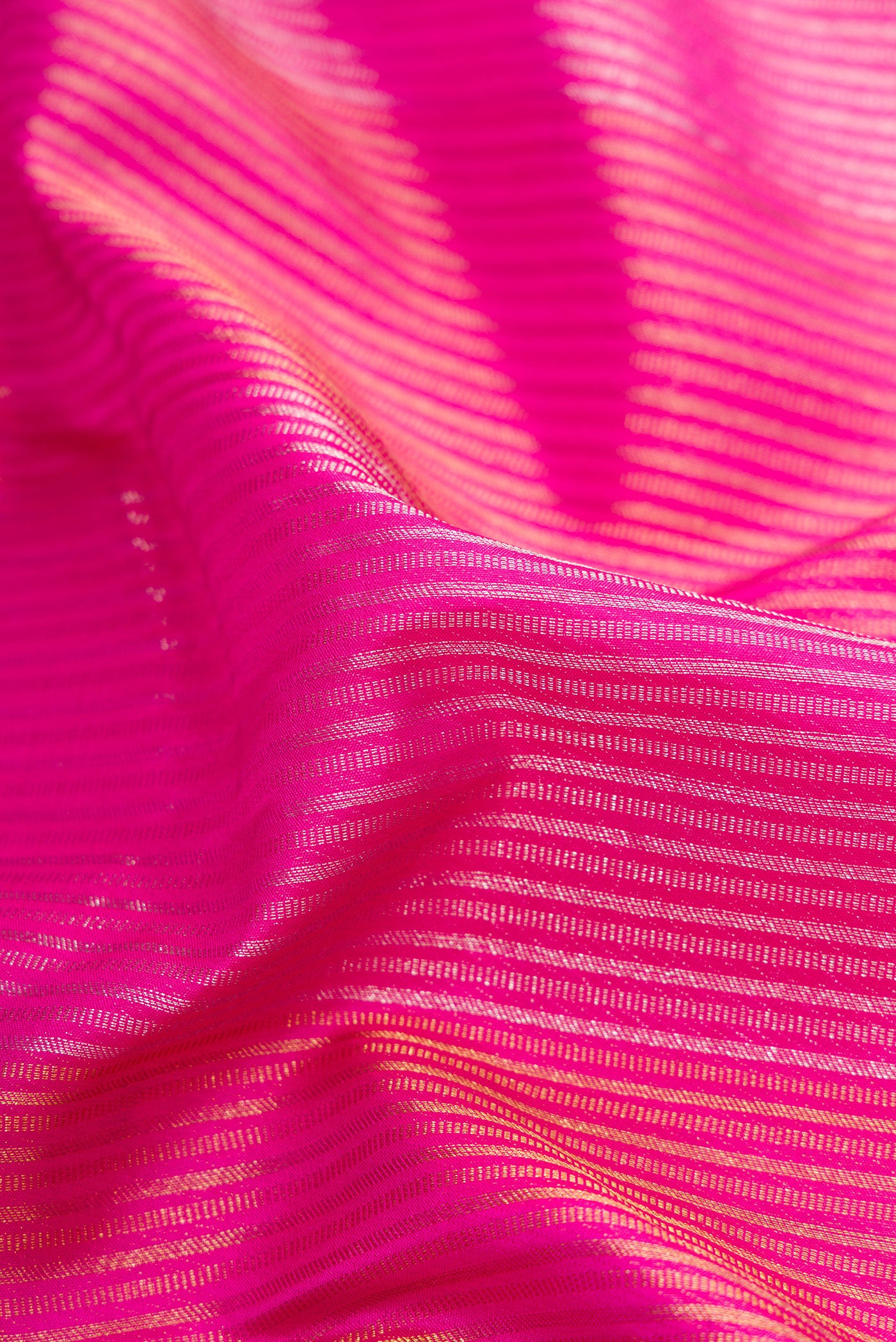 Close up of Pink Dual Tone Kanjivaram Silk Saree with Stripes on the body and Fancy Border.  displaying folds