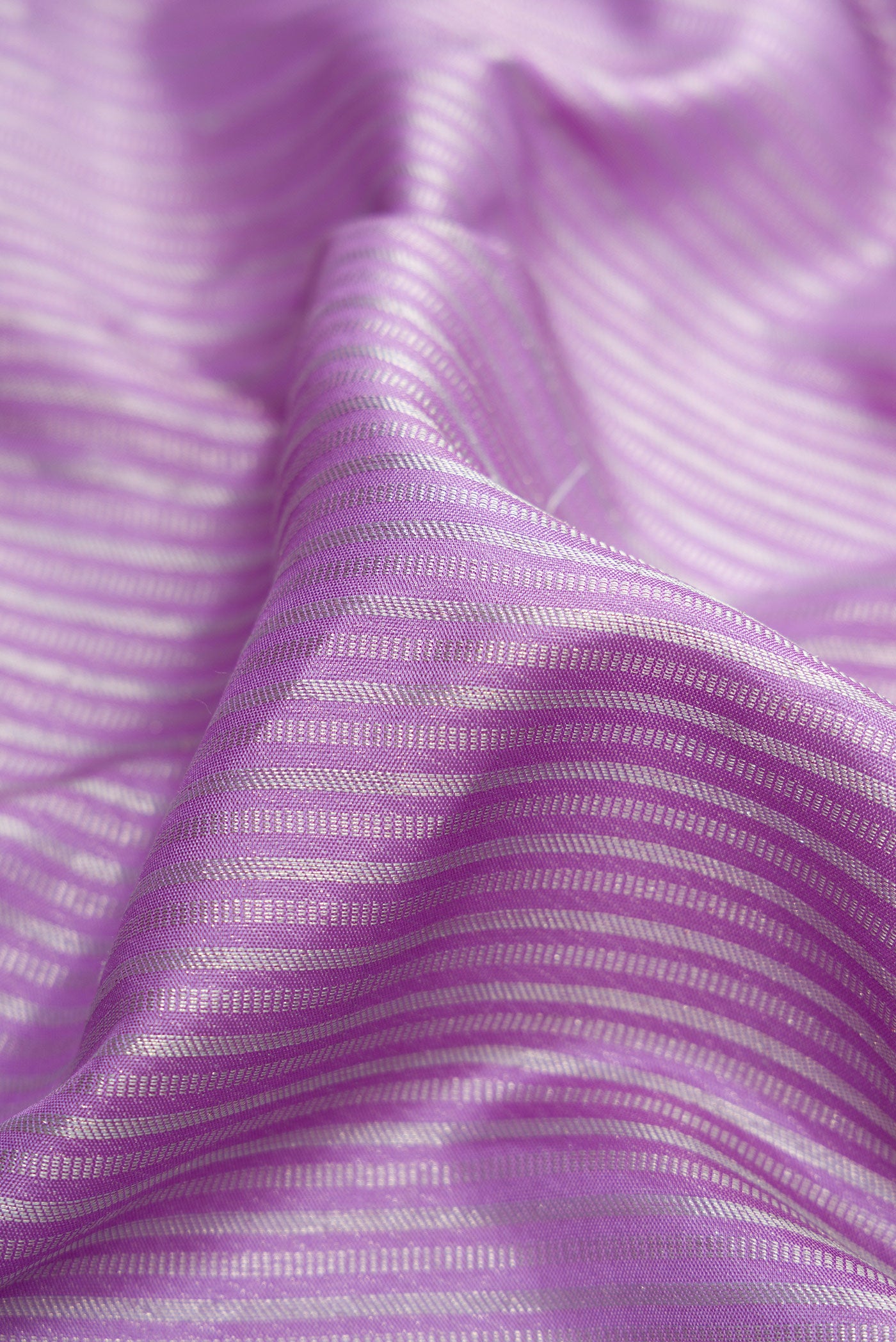 Close up of Lavender Dual Tone Kanjivaram Silk Saree with Stripes on the body and Zari Border.  displaying folds