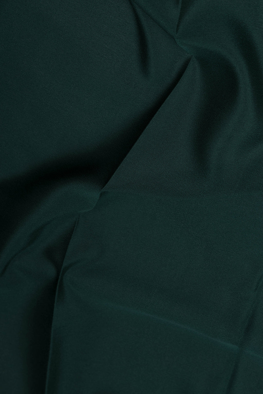 Close up of Bottle Green Mysore Crepe Saree with Plain Body and Zari Border.  displaying folds