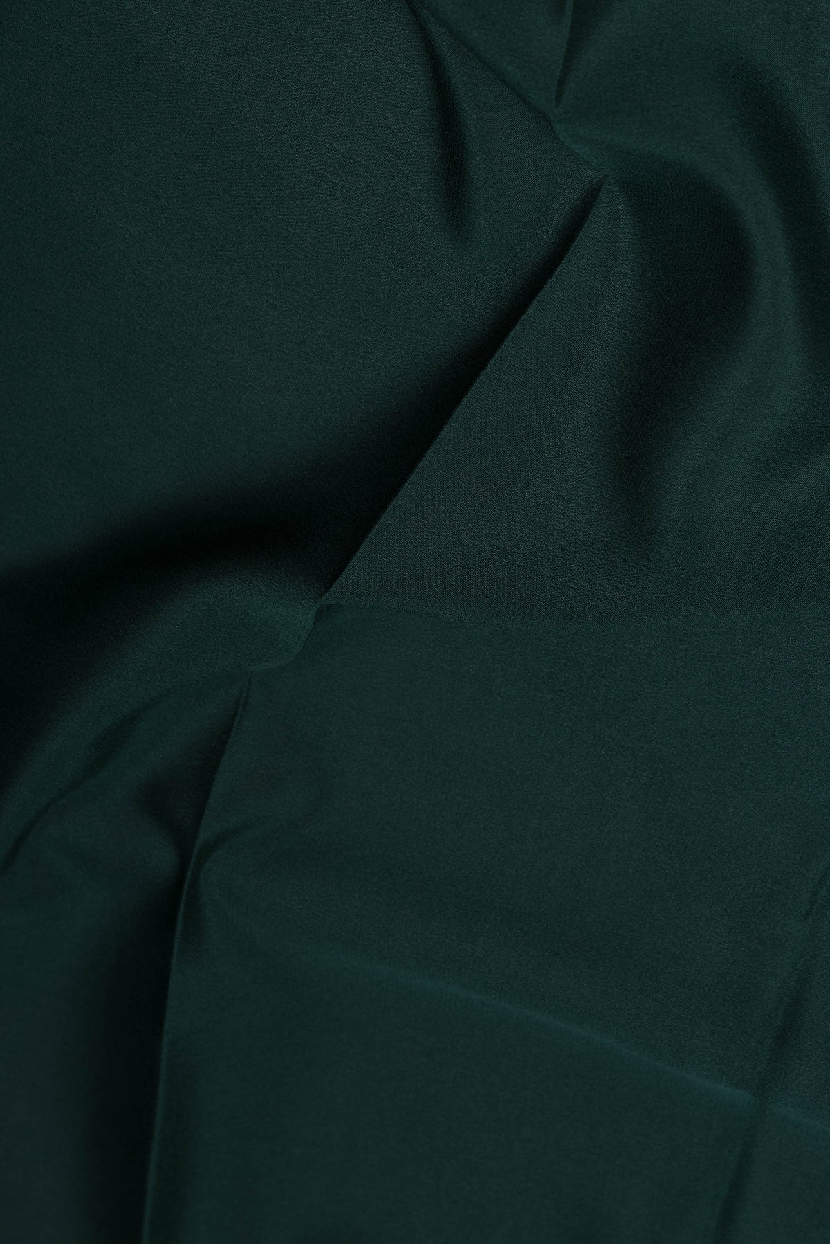 Close up of Bottle Green Mysore Crepe Saree with Plain Body and Zari Border.  displaying folds