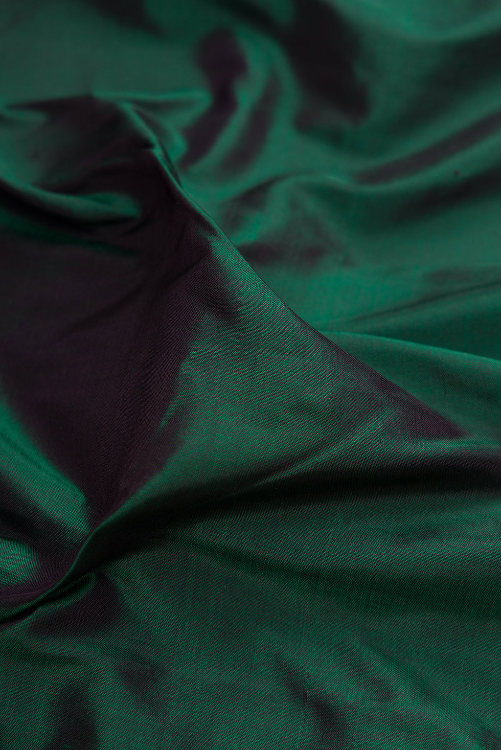 Close up of Bottle Green Kanjivaram Silk Saree with Plain Body and Zari Border.  displaying folds