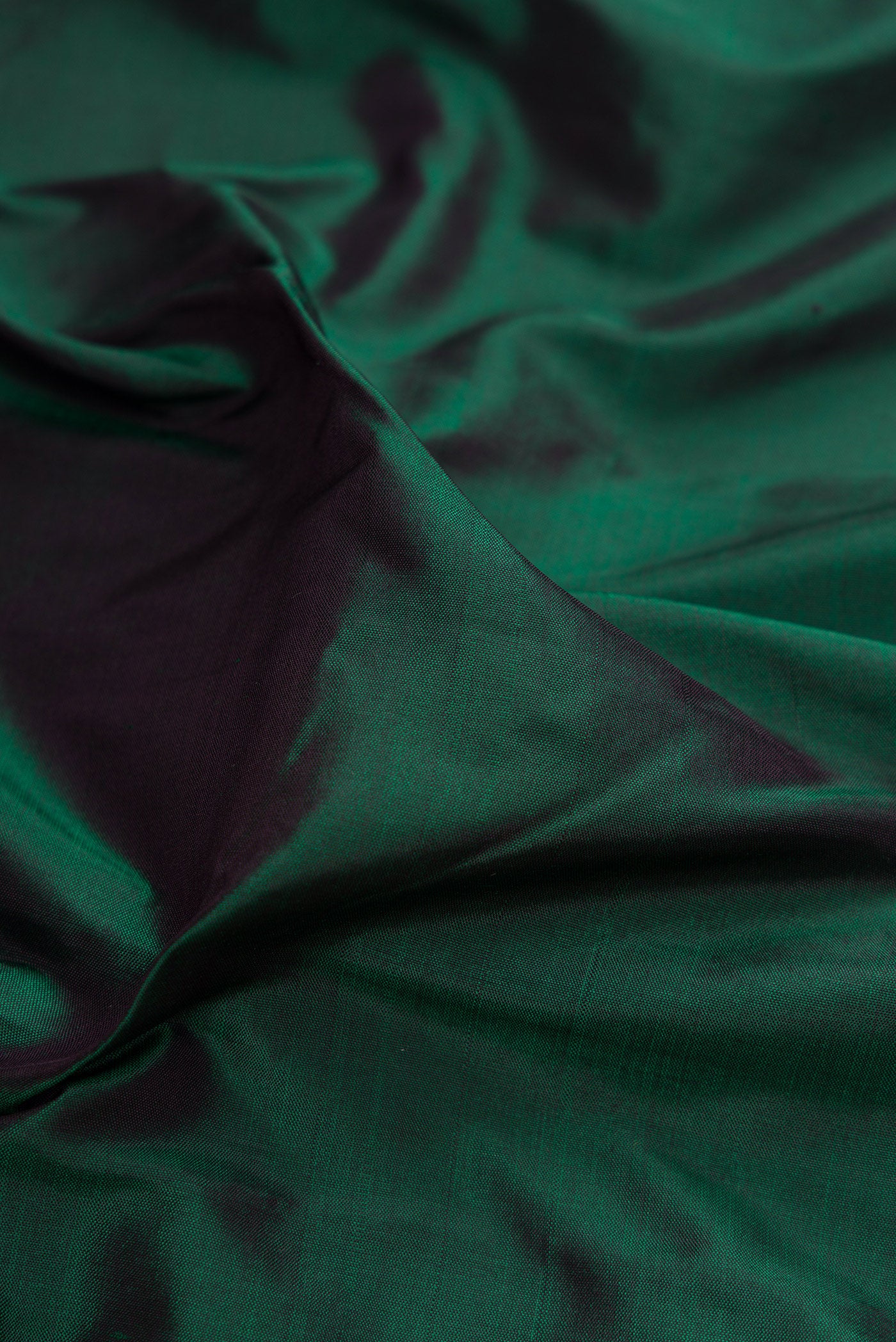 Close up of Bottle Green Kanjivaram Silk Saree with Plain Body and Zari Border.  displaying folds