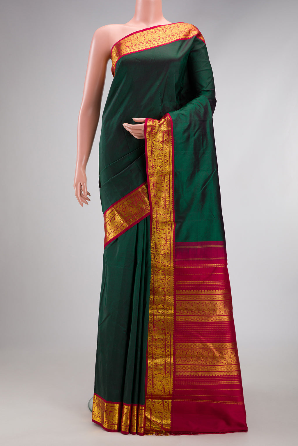 Bottle Green Kanjivaram Silk Saree with Plain Body and Zari Border.  displayed on a mannequin