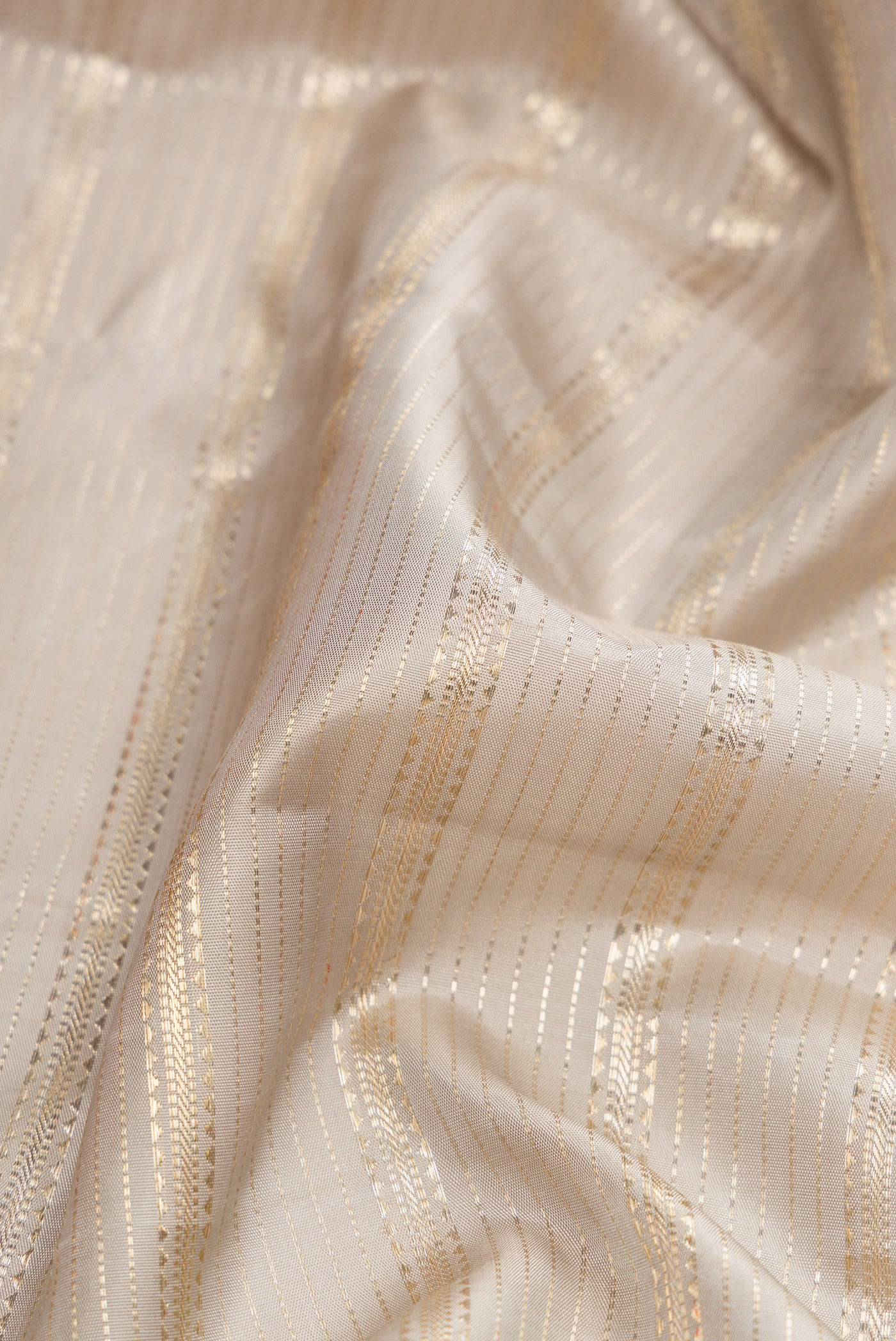Close up of Grey Dual Tone Kanchipuram Silk Saree with Zari Brocade on the body and Zari Border.  displaying folds