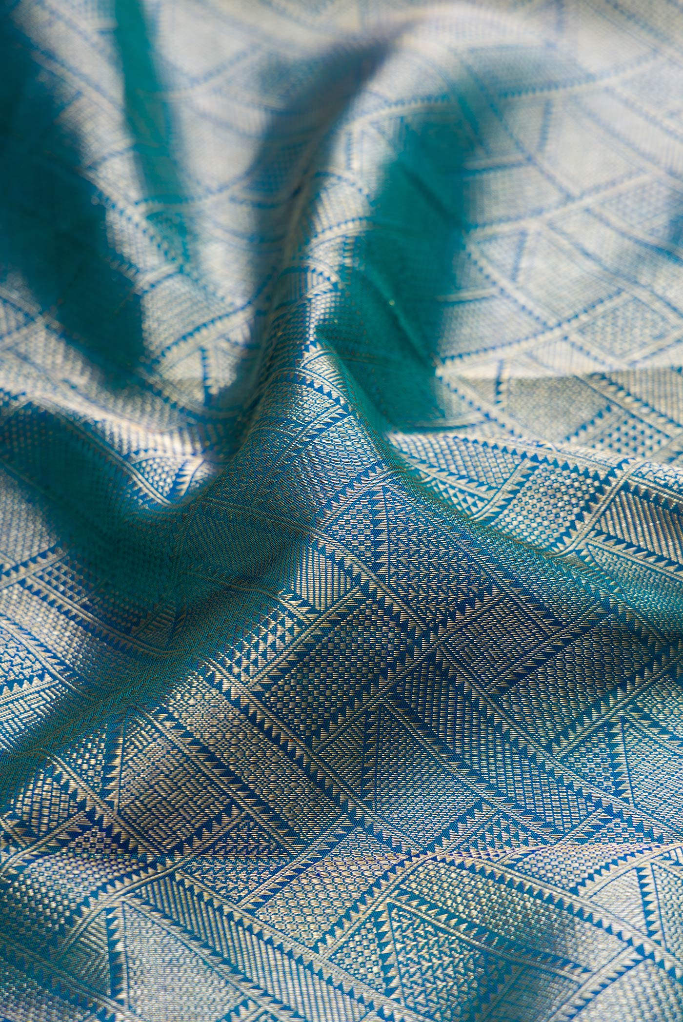 Close up of Peacock Blue Kanchipuram Silk Saree with Zari Brocade on the body and Fancy Border.  displaying folds