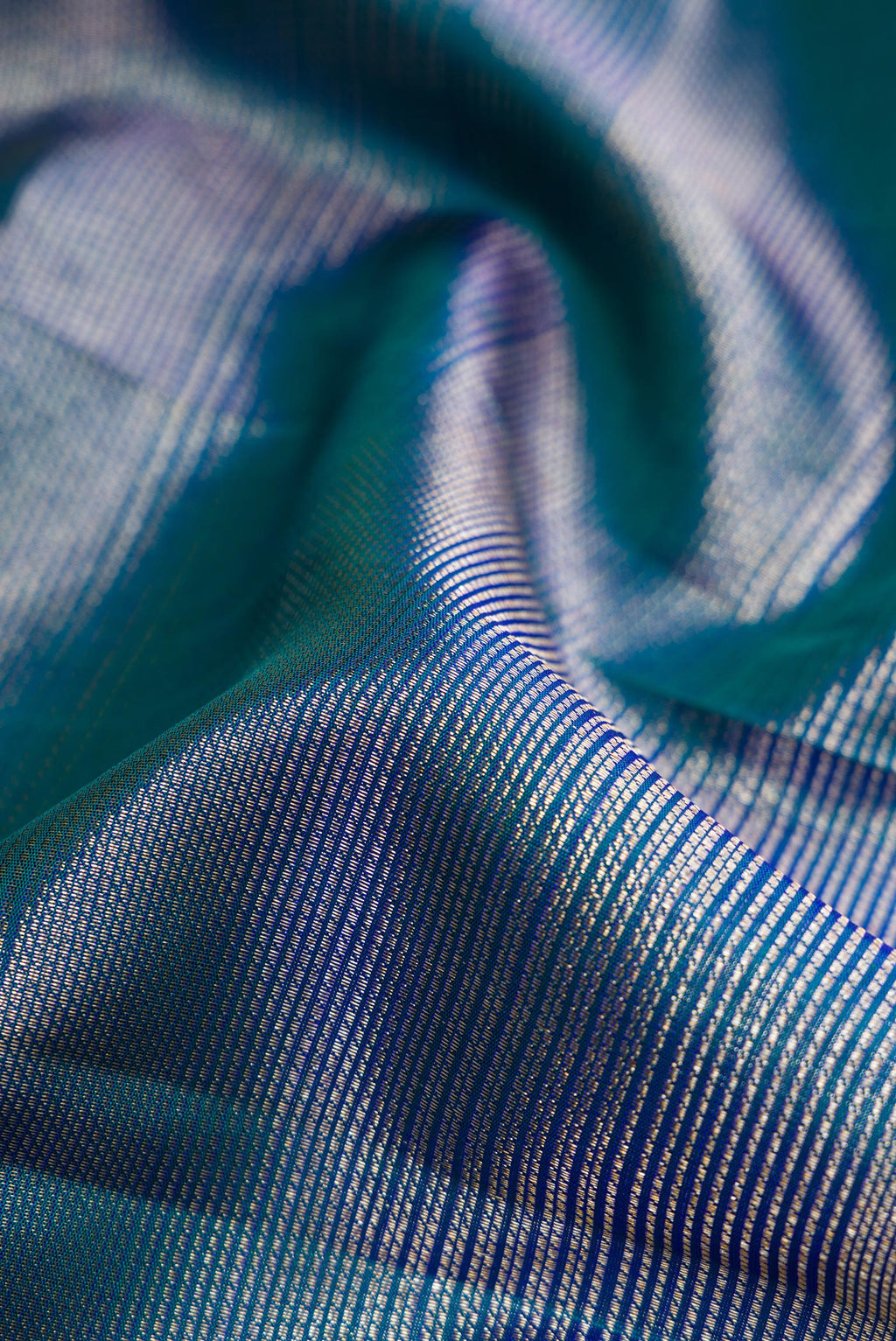 Close up of Peacock Blue Dual Tone Kanchipuram Silk Saree with Zari Brocade on the body and Zari Border.  displaying folds