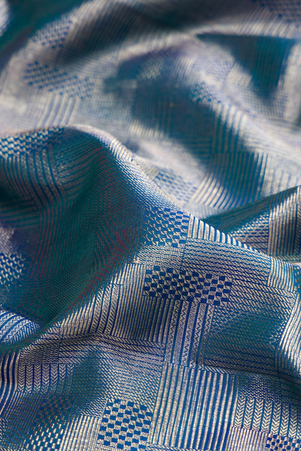 Close up of Peacock Blue Kanchipuram Silk Saree with Zari Brocade on the body and Zari Border.  displaying folds