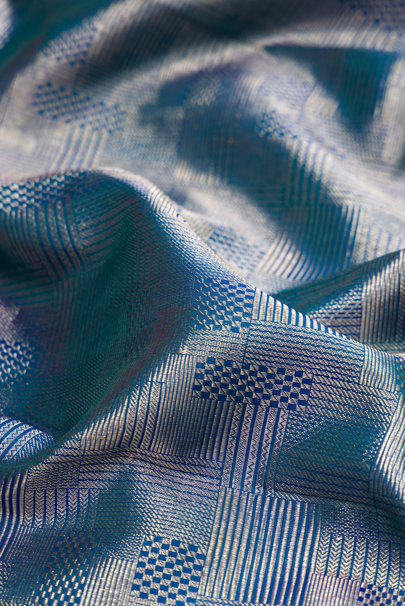 Close up of Peacock Blue Kanchipuram Silk Saree with Zari Brocade on the body and Zari Border.  displaying folds