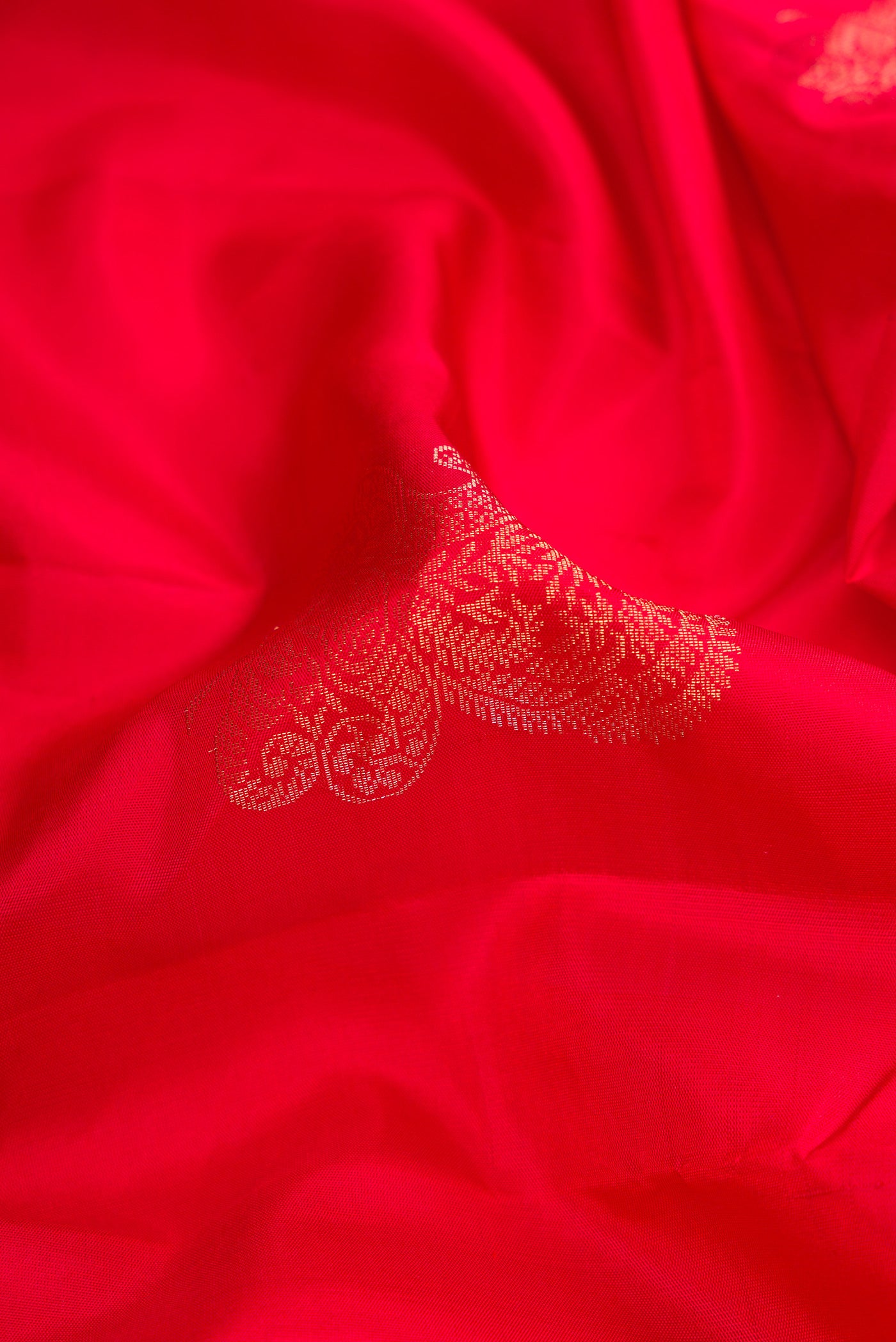 Close up of Red Dual Tone Kanjivaram Silk Saree with Zari Butta on the body and Without Border.  displaying folds