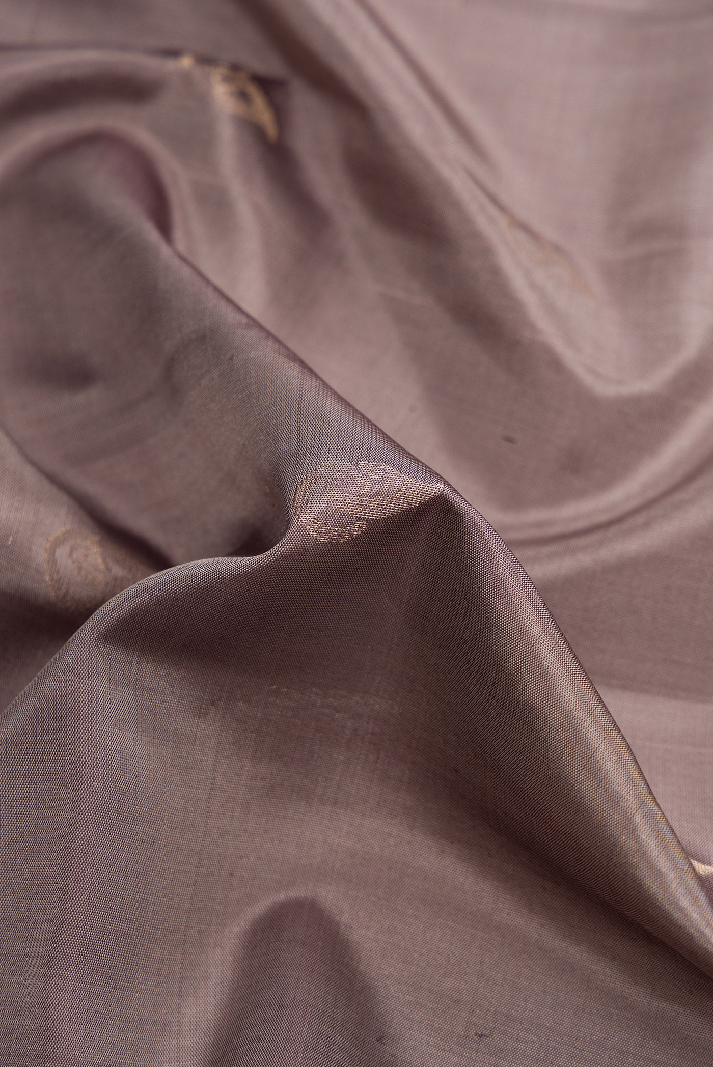 Close up of Grey Dual Tone Soft Silk Saree with Zari Butta on the body and Zari Border.  displaying folds