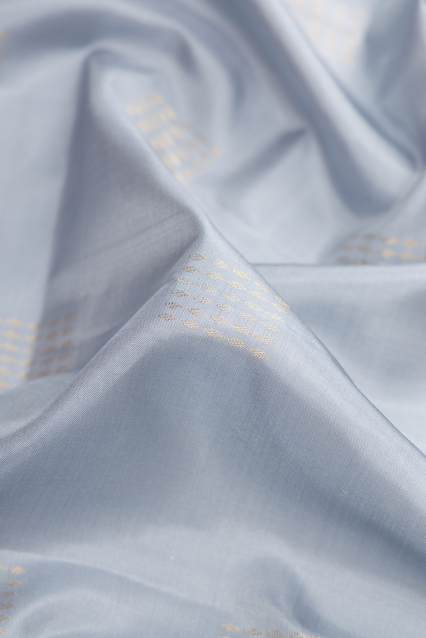 Close up of Grey Dual Tone Soft Silk Saree with Zari Butta on the body and Zari Border.  displaying folds