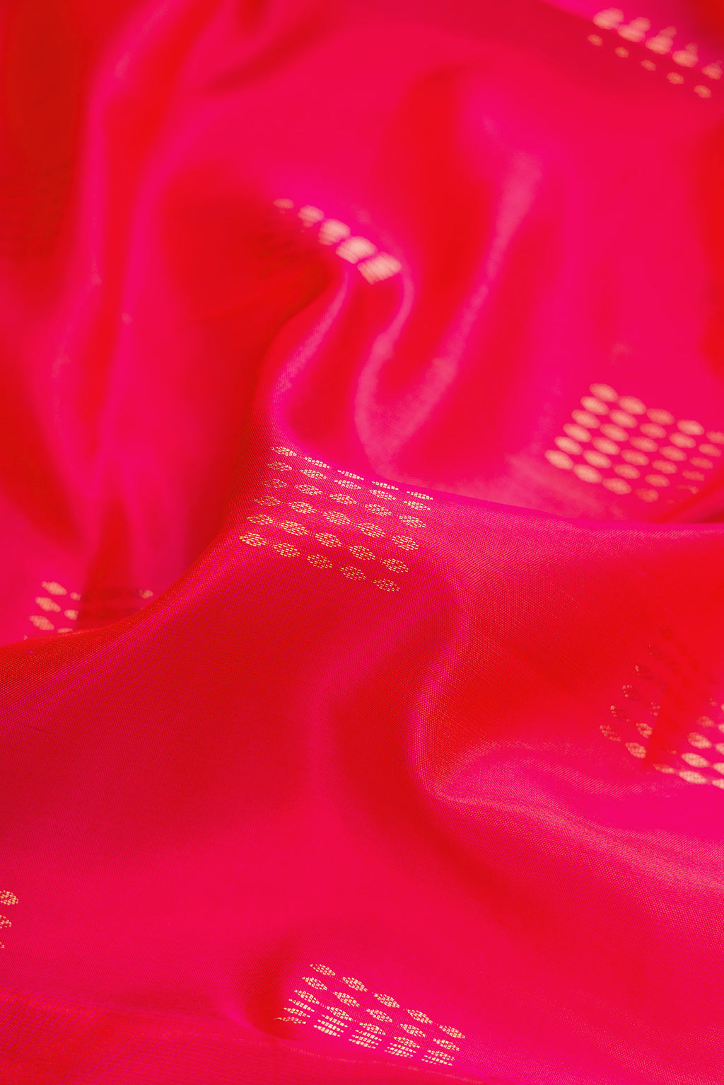 Close up of Coral Dual Tone Soft Silk Saree with Zari Butta on the body and Zari Border.  displaying folds