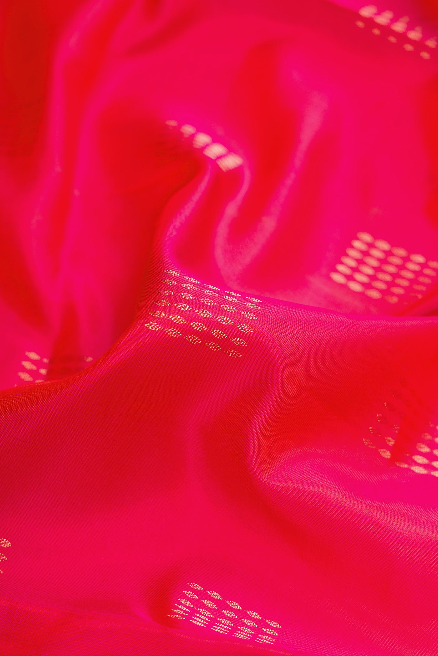 Close up of Coral Dual Tone Soft Silk Saree with Zari Butta on the body and Zari Border.  displaying folds