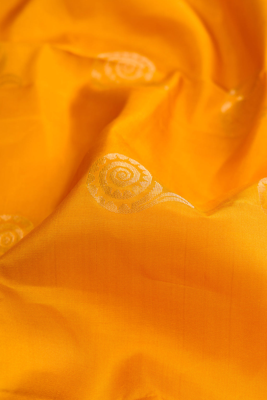 Close up of Mustard Dual Tone Soft Silk Saree with Zari Butta on the body and Without Border.  displaying folds