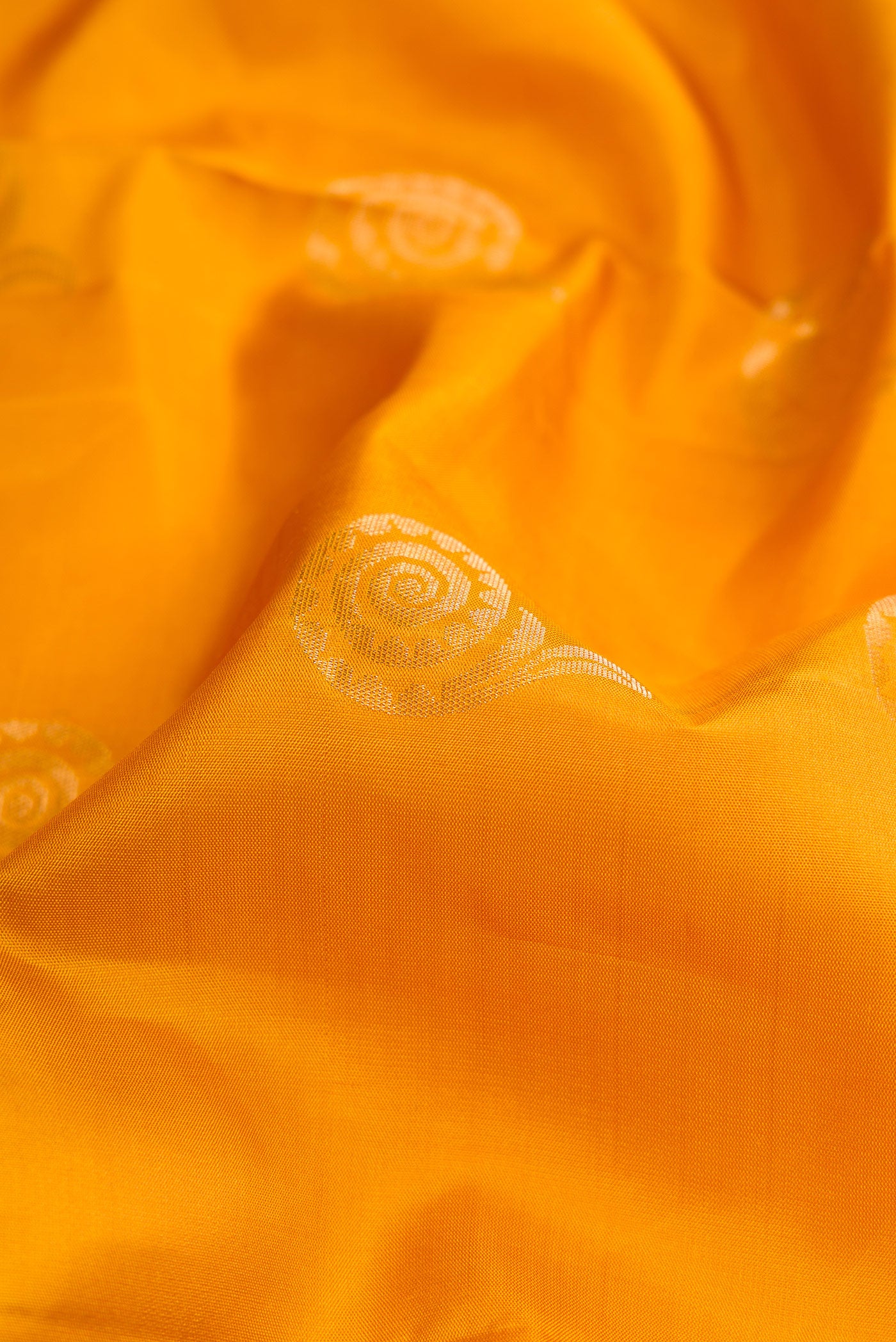 Close up of Mustard Dual Tone Soft Silk Saree with Zari Butta on the body and Without Border.  displaying folds