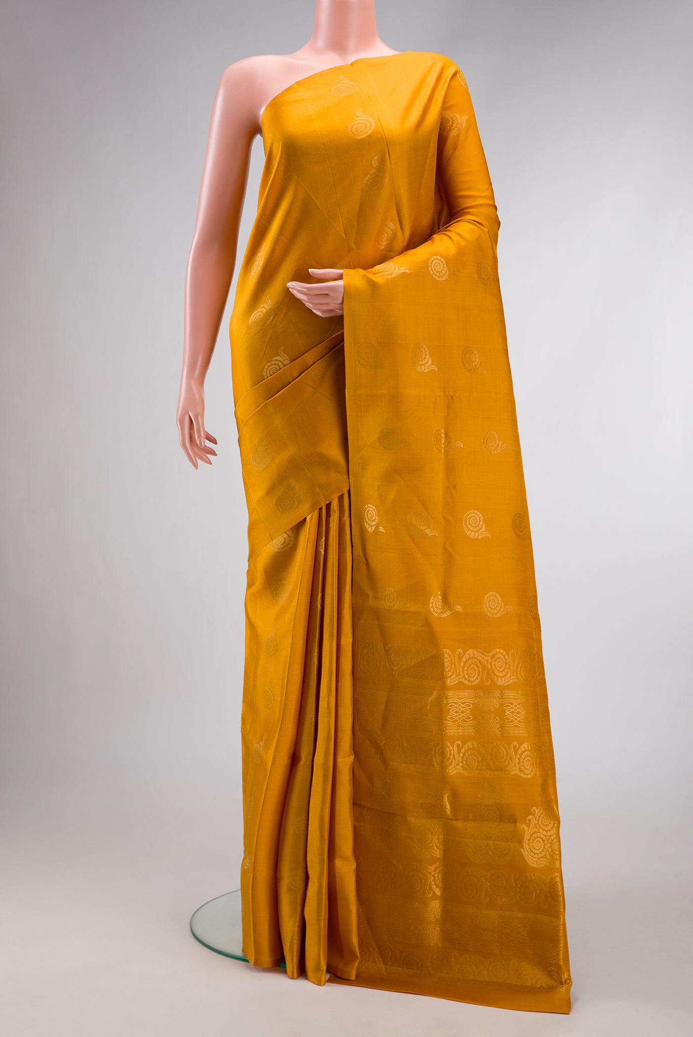 Mustard Dual Tone Soft Silk Saree with Zari Butta on the body and Without Border.  displayed on a mannequin