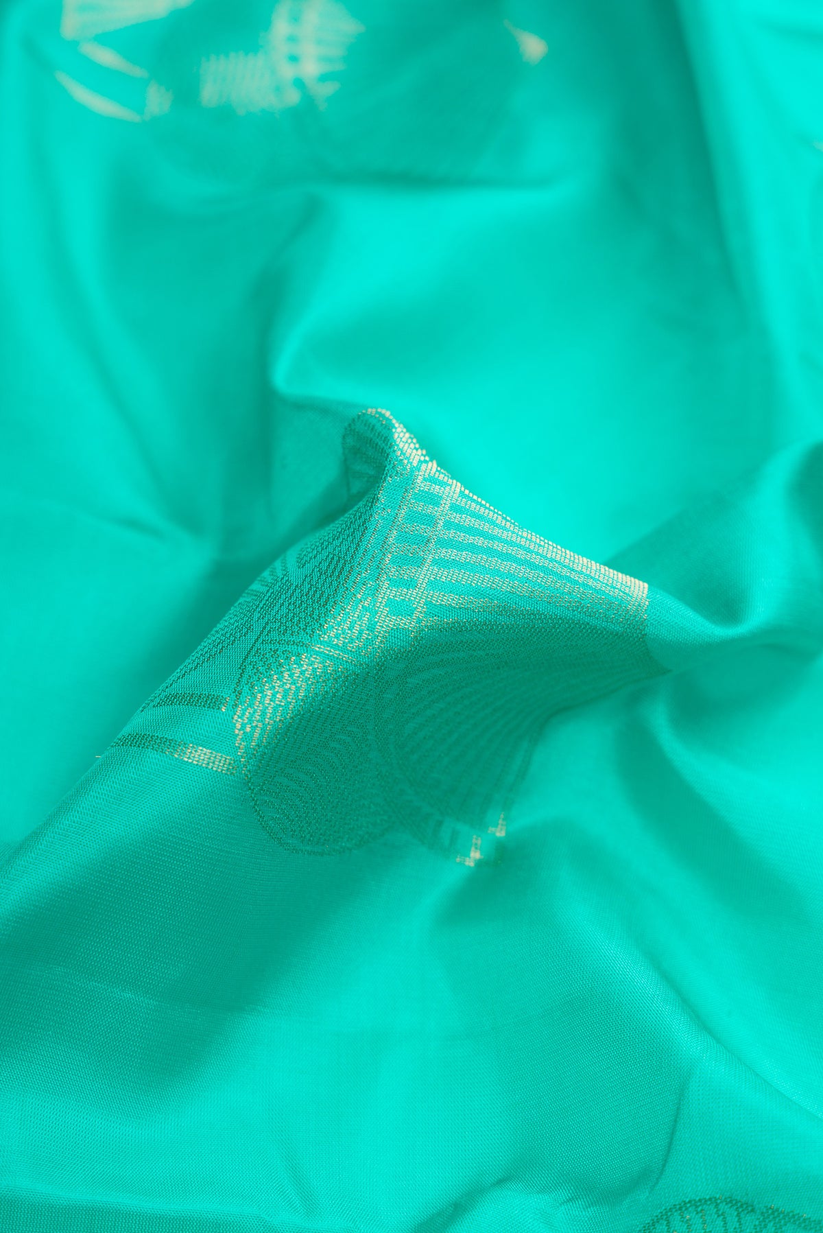 Close up of Sea Green Dual Tone Soft Silk Saree with Zari Butta on the body and Without Border.  displaying folds