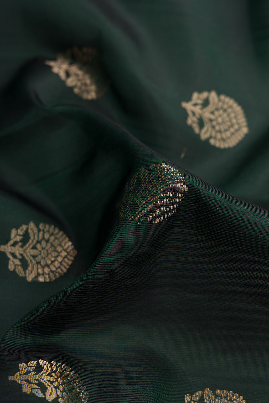 Close up of Bottle Green Dual Tone Soft Silk Saree with Zari Butta on the body and Zari Border.  displaying folds