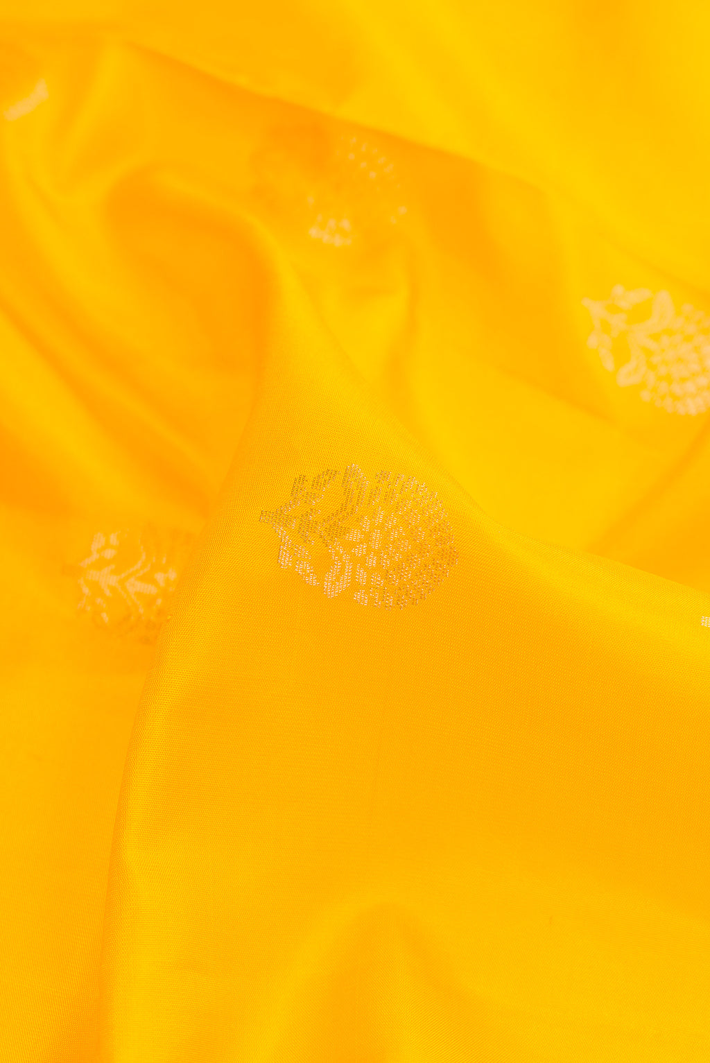 Close up of Yellow Dual Tone Soft Silk Saree with Zari Butta on the body and Zari Border.  displaying folds