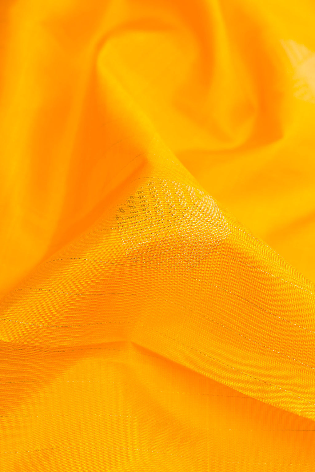 Close up of Yellow Dual Tone Soft Silk Saree with Zari Butta on the body and Without Border.  displaying folds