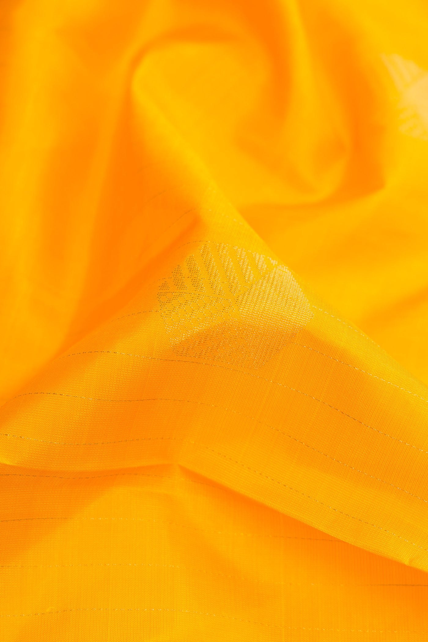 Close up of Yellow Dual Tone Soft Silk Saree with Zari Butta on the body and Without Border.  displaying folds
