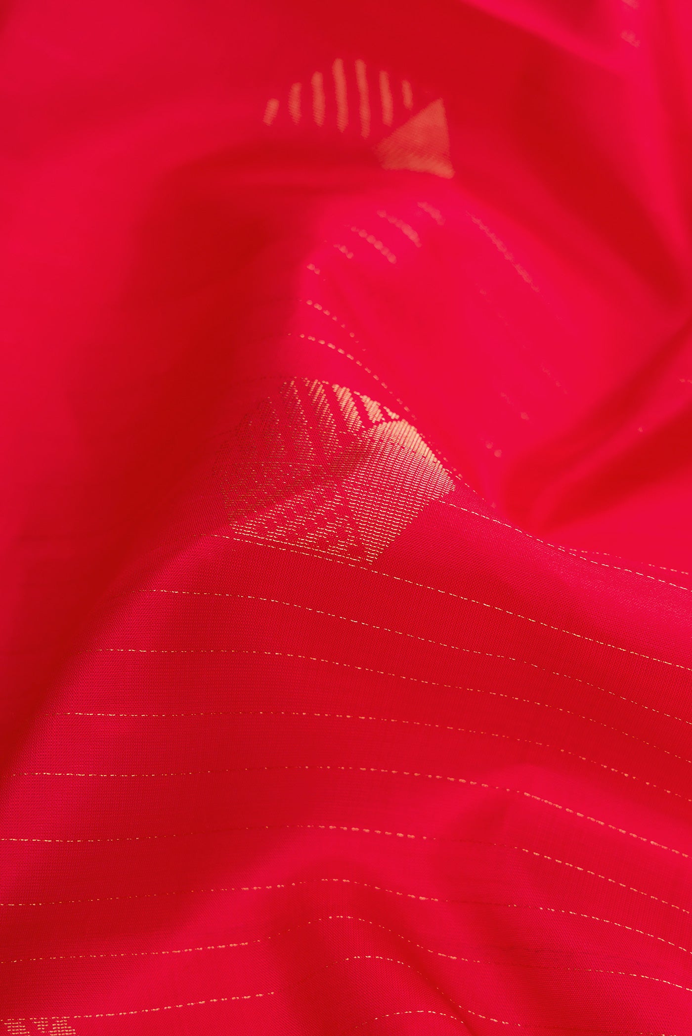Close up of Red Dual Tone Soft Silk Saree with Zari Butta on the body and Without Border.  displaying folds