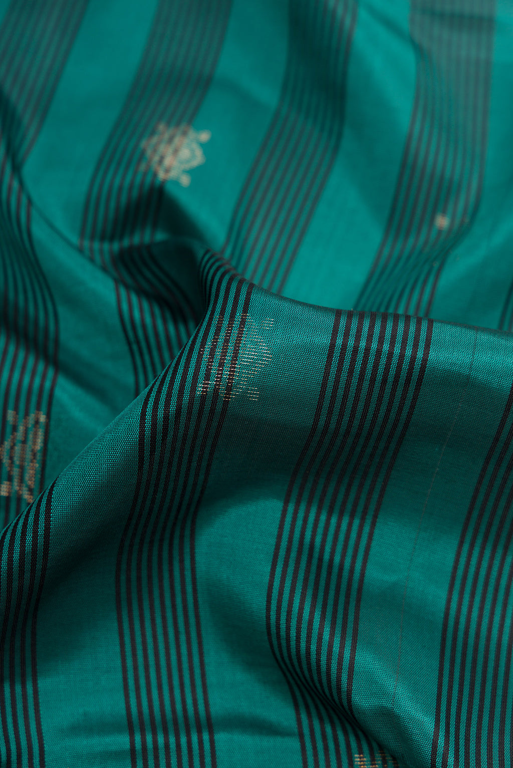 Close up of Maya Blue Dual Tone Soft Silk Saree with Zari Butta on the body and Zari Border.  displaying folds
