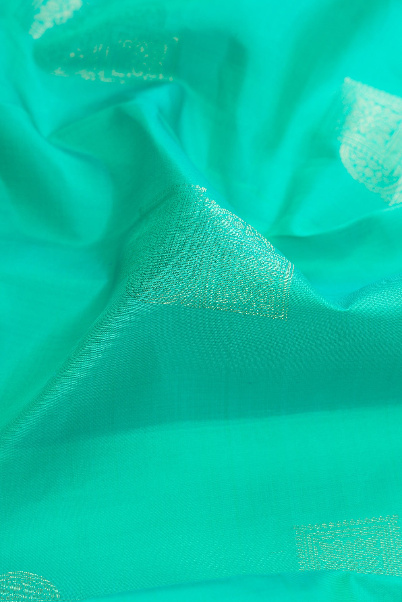 Close up of Sea Green Dual Tone Kanjivaram Silk Saree with Zari Butta on the body and Without Border.  displaying folds