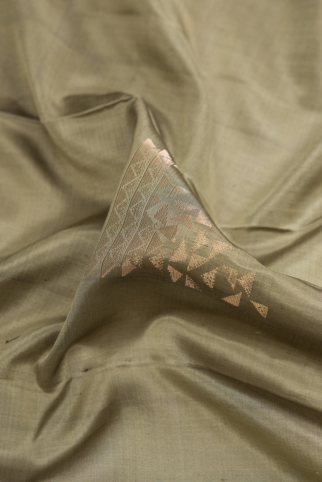 Close up of Grey Dual Tone Soft Silk Saree with Zari Butta on the body and Zari Border.  displaying folds