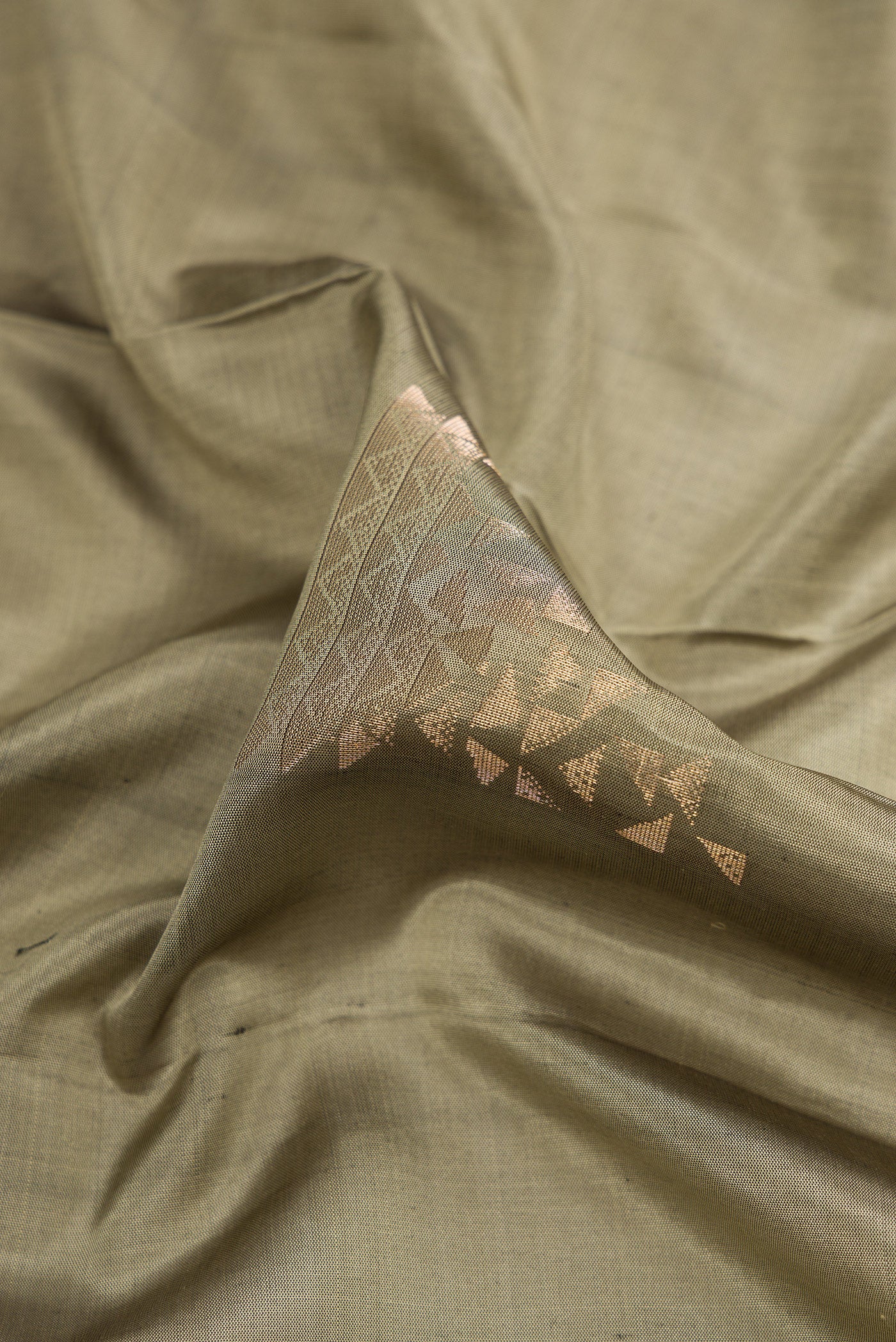 Close up of Grey Dual Tone Soft Silk Saree with Zari Butta on the body and Zari Border.  displaying folds