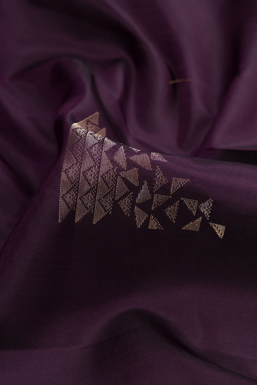 Close up of Burgundy Dual Tone Soft Silk Saree with Zari Butta on the body and Zari Border.  displaying folds