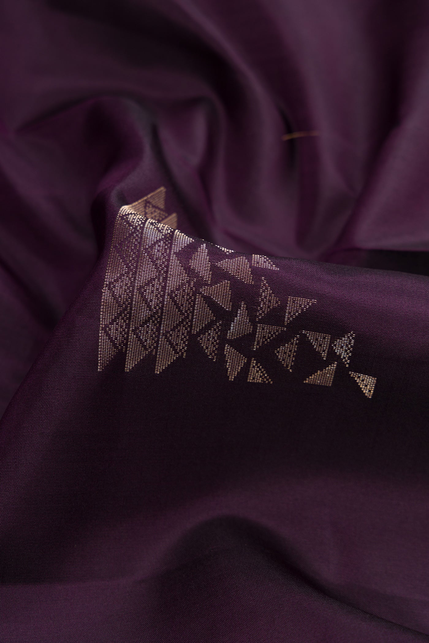 Close up of Burgundy Dual Tone Soft Silk Saree with Zari Butta on the body and Zari Border.  displaying folds
