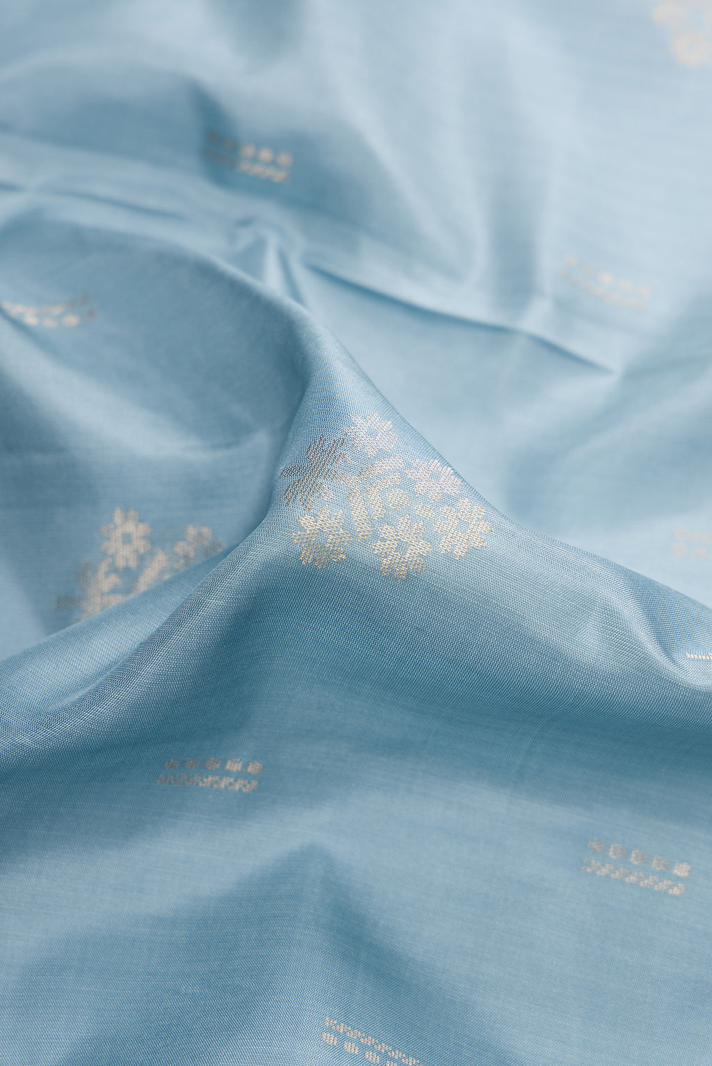 Close up of Light Blue Dual Tone Soft Silk Saree with Zari Butta on the body and Zari Border.  displaying folds