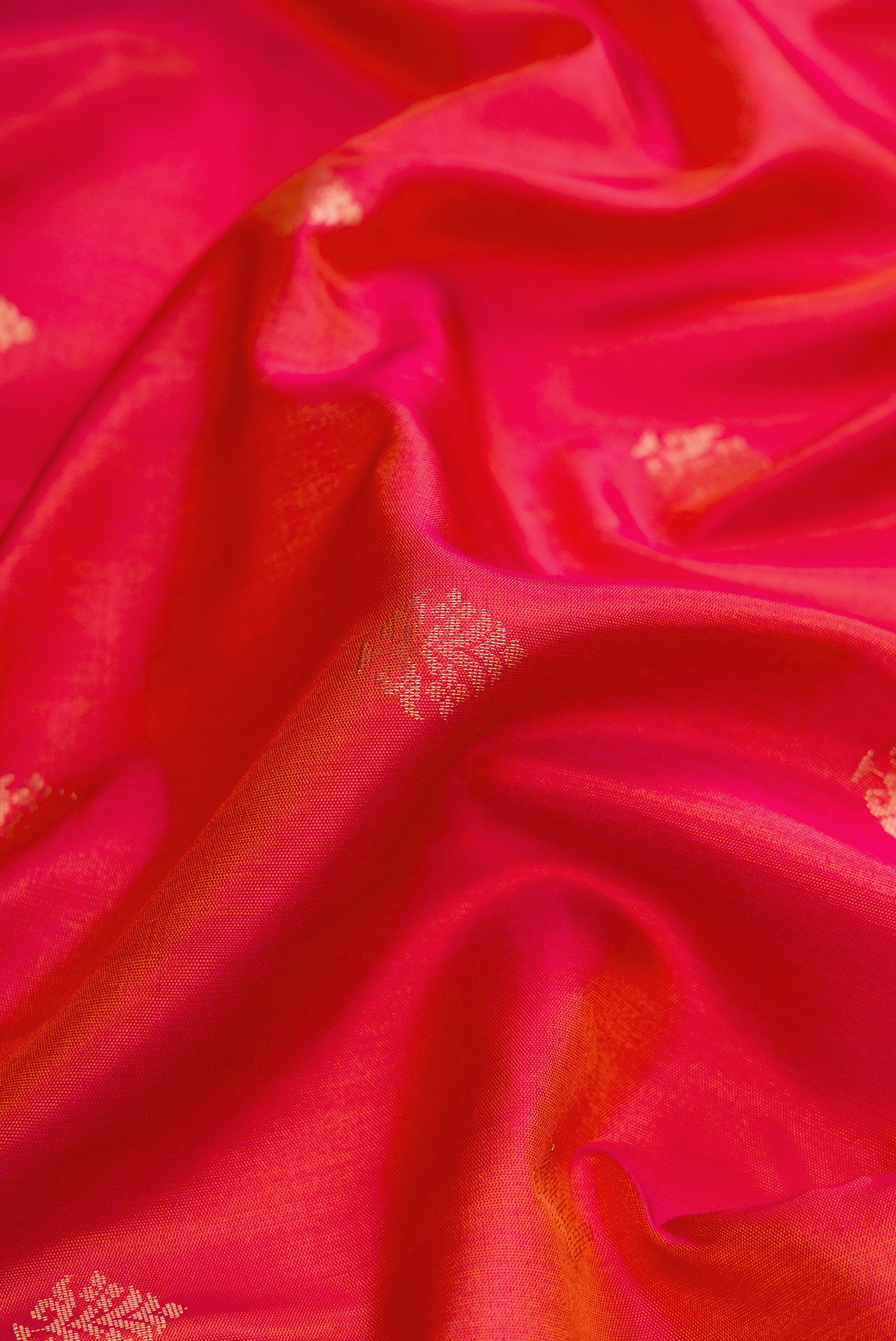 Close up of Brick Orange Dual Tone Soft Silk Saree with Zari Butta on the body and Zari Border.  displaying folds