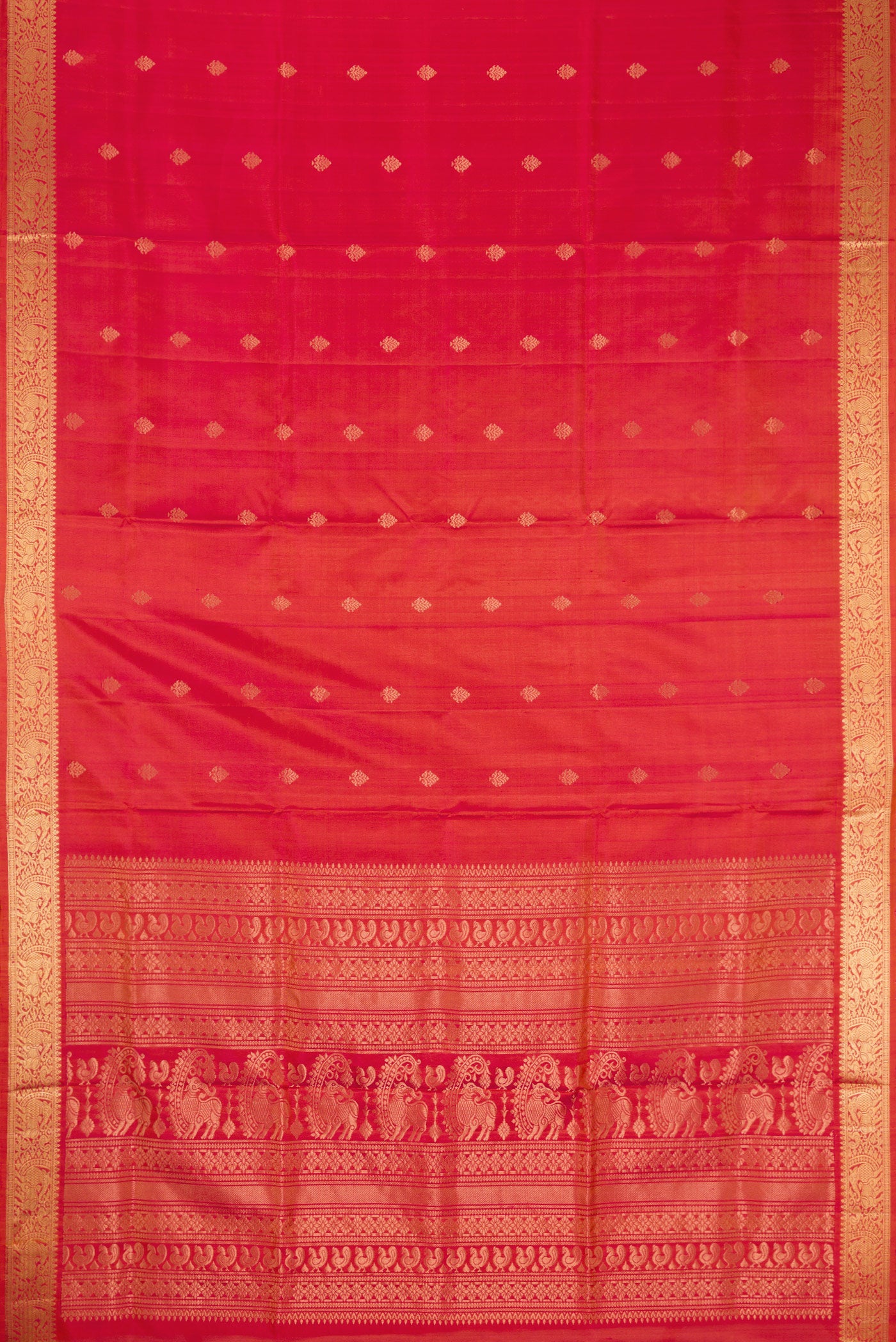 Flat view of Brick Orange Dual Tone Soft Silk Saree with Zari Butta on the body and Zari Border. 