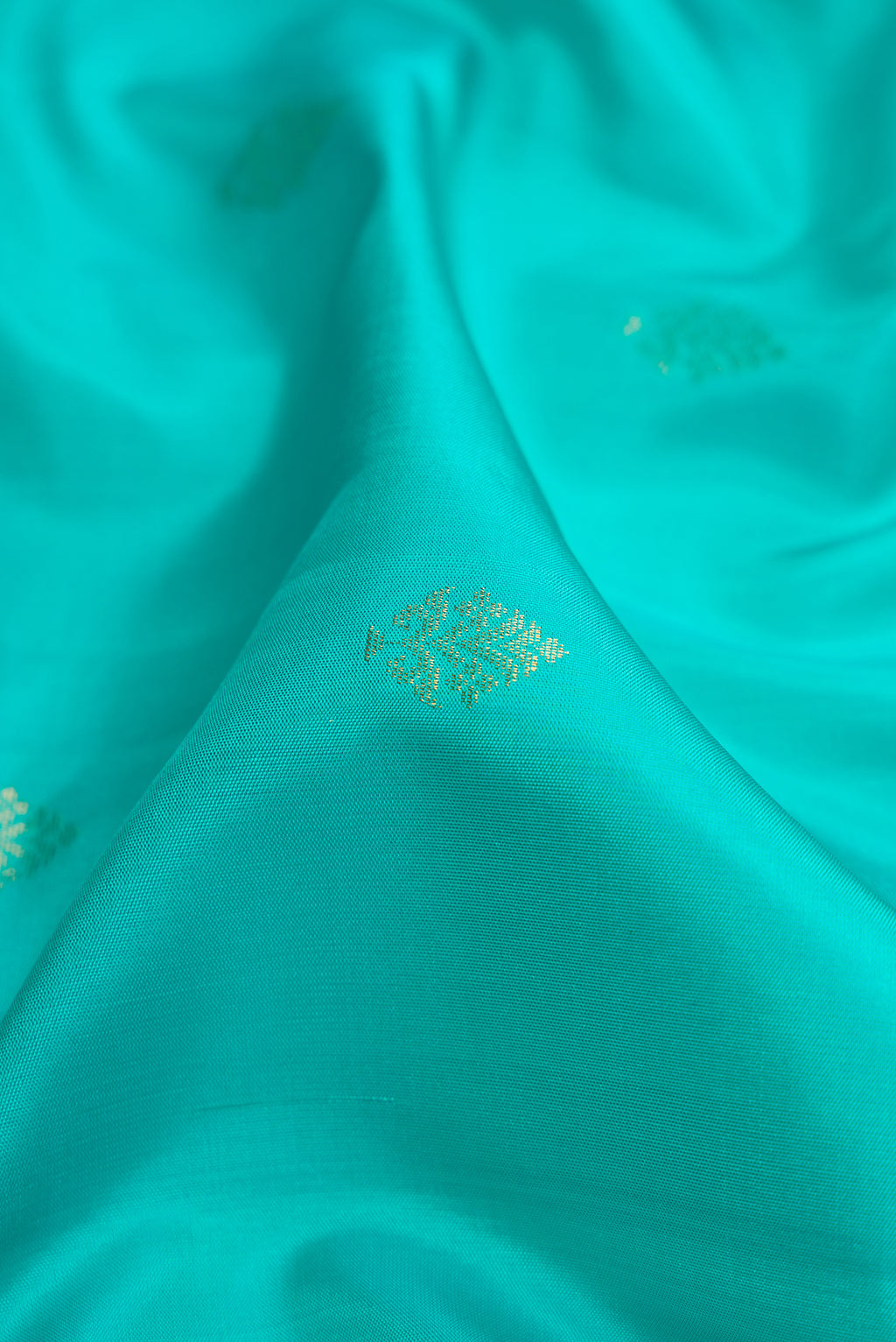 Close up of Sky Blue Dual Tone Soft Silk Saree with Zari Butta on the body and Zari Border.  displaying folds